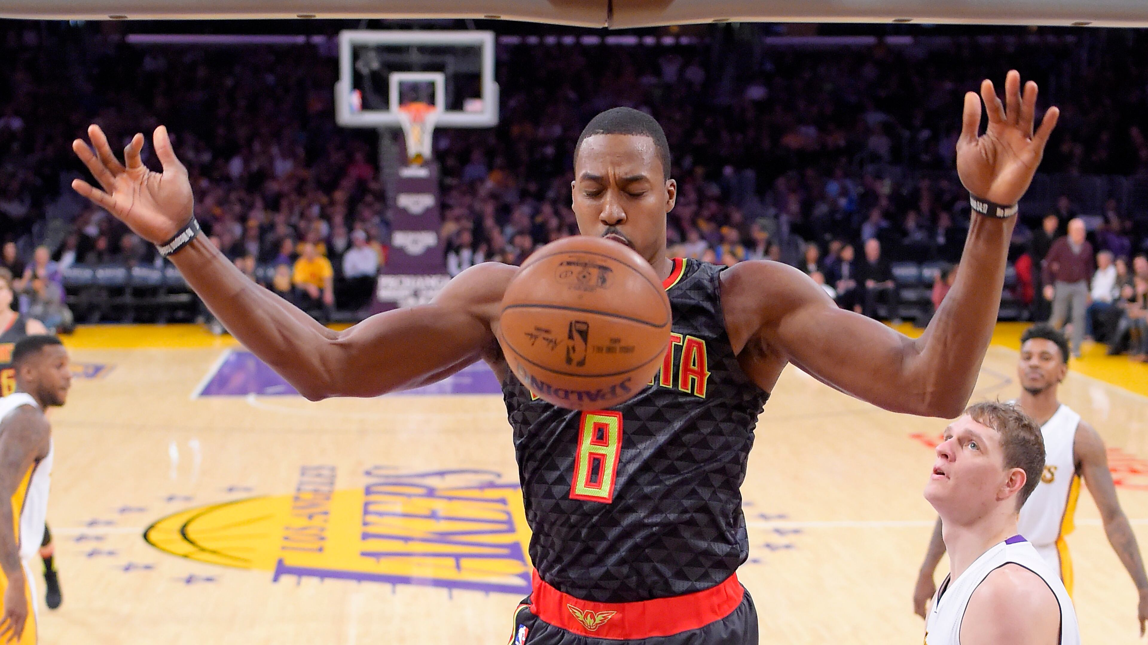 Atlanta Hawks center Dwight Howard, center, dunks as Los Angeles Lakers center Timofey Mozgov, lower right, of Russia, and Los Angeles Lakers guard Nick Young, upper right, watch during the first half of an NBA basketball game, Sunday, Nov. 27, 2016, in Los Angeles. (AP Photo/Mark J. Terrill)