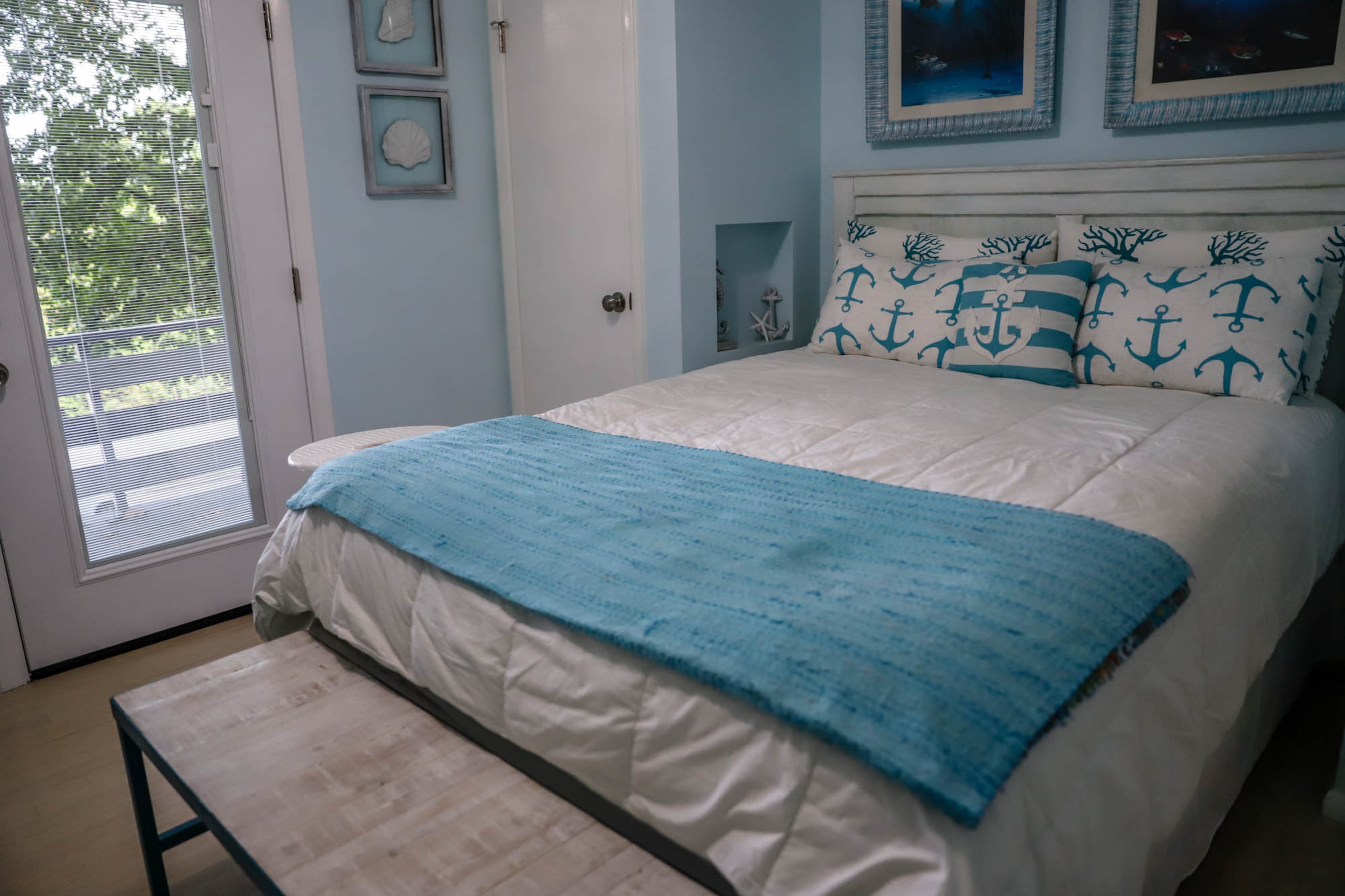 In order to make a bedroom larger, a closet was removed where the bed now rests on the recessed wall. The result is a cozy space with a bright, coastal feeling.