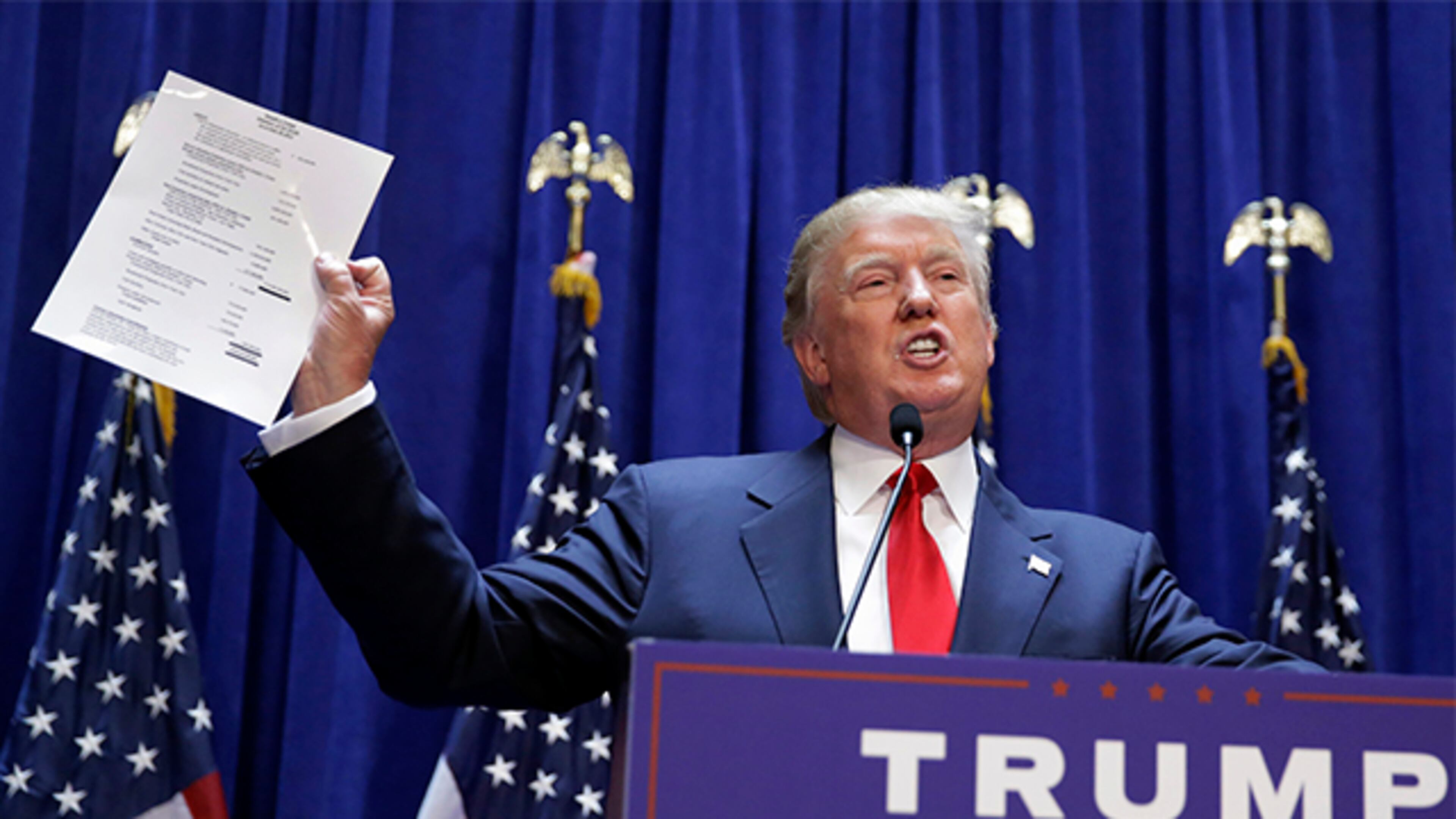 Developer Donald Trump displays a copy of his net worth during his announcement that he will seek the Republican nomination for president, Tuesday, June 16, 2015, in the lobby of Trump Tower in New York. (AP Photo/Richard Drew)