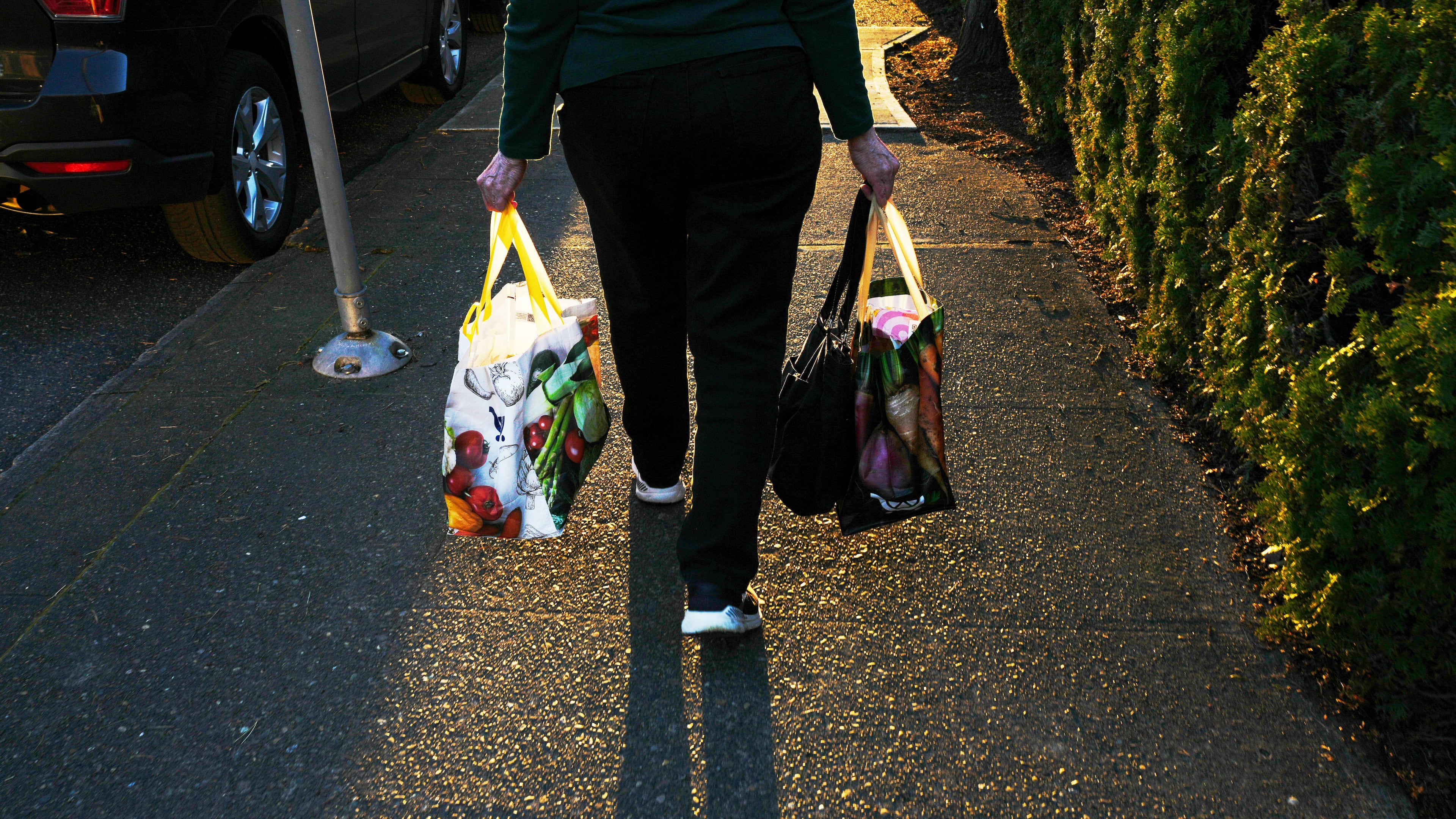 FILE - A woman carries reuable shopping bags to her car March 16, 2026, in Portland, Ore. (AP Photo/Jenny Kane, File)