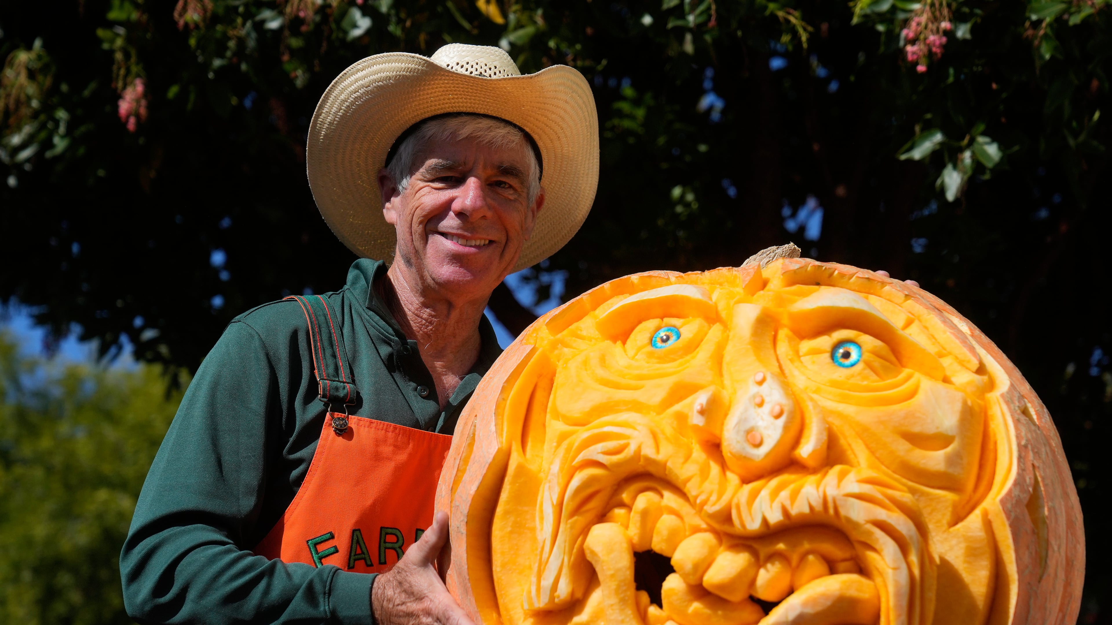 Farmer Mike Valladao poses next to a pumpkin he carved at the Safeway World Championship Pumpkin Weigh-Off, Monday, Oct. 12, 2026, in Half Moon Bay, Calif. (AP Photo/Jeff Chiu)