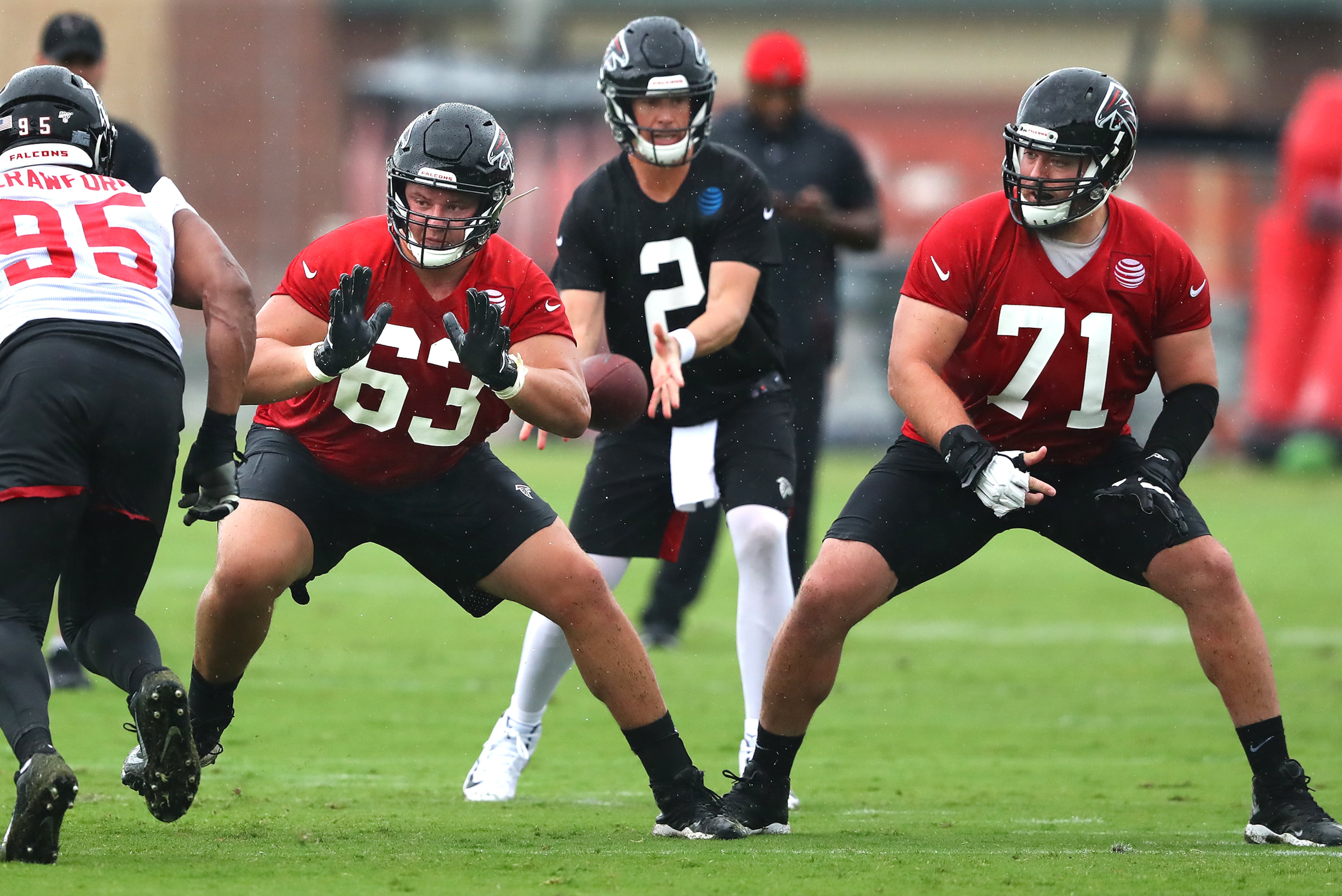 Falcons offensive linemen Chris LIndstrom (left) and Wes Schweitzer give Matt Ryan protection during the second practice at training camp on Tuesday. Curtis Compton/ccompton@ajc.com