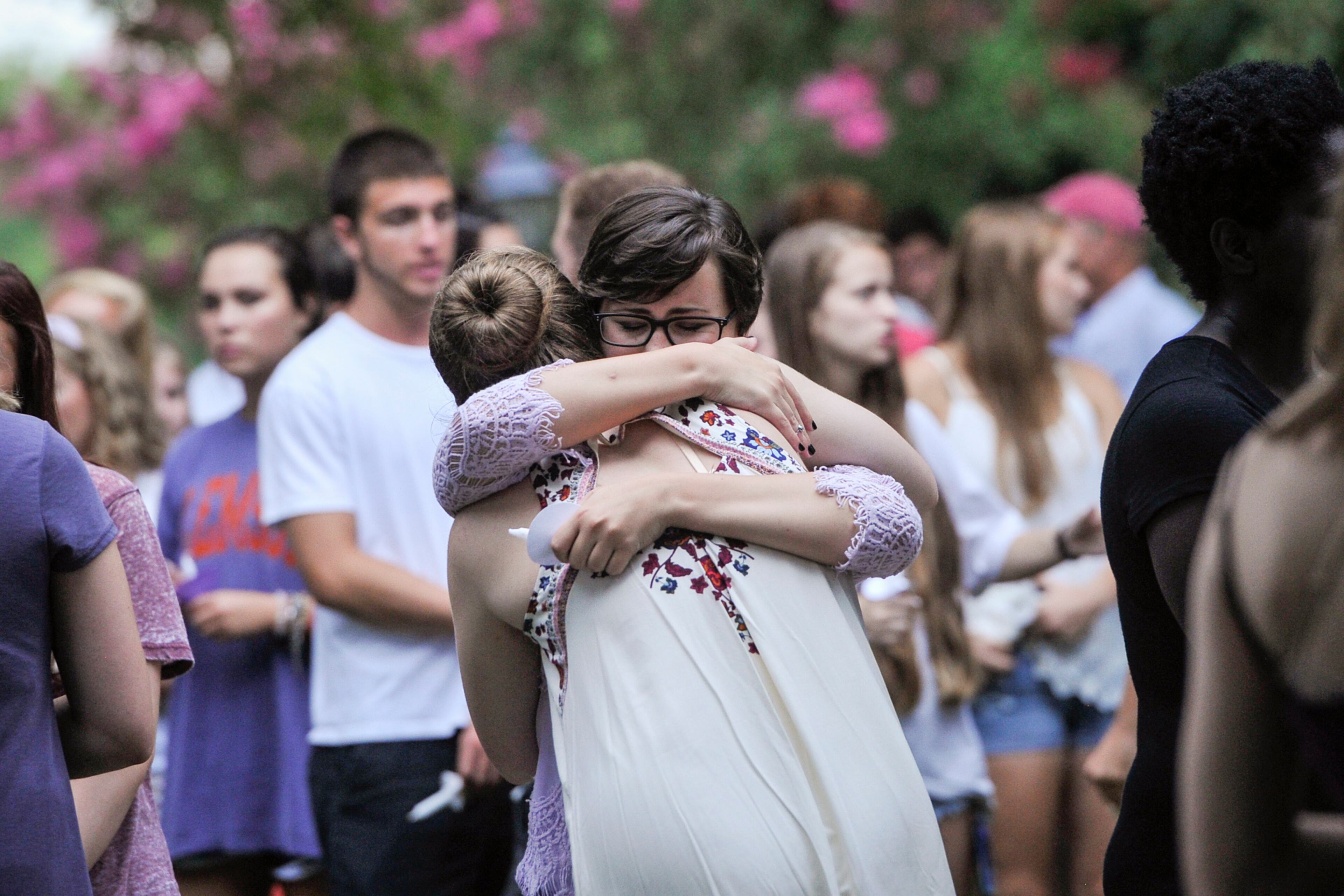 Friends of Natalie Henderson hug during a vigil held for her on the old Roswell Square, Thursday, Aug. 4, 2016. Henderson and Carter Davis of Woodstock, both 17, were found Monday behind a Publix, grocery store shot to death. Jeffrey A. Hazelwood, 20, was arrested Wednesday and will be charged with two counts of murder in the deaths. (Photo Contributed by John Amis)