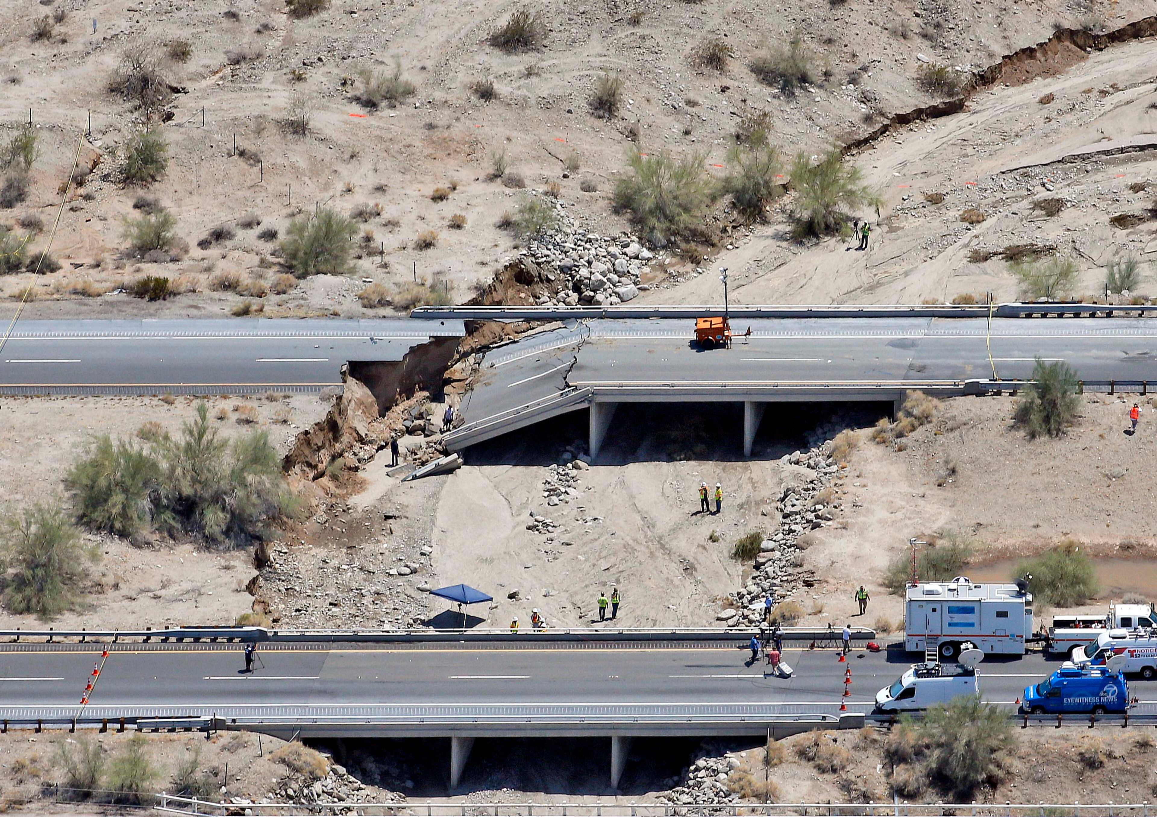 A collapsed elevated section of Interstate 10 is seen from the air, Monday, July 20, 2015, in Desert Center, Calif. All traffic along one of the major highways connecting California and Arizona was blocked indefinitely when the bridge over a desert wash collapsed during a major storm, and the roadway in the opposite direction sustained severe damage. (AP Photo/Matt York)