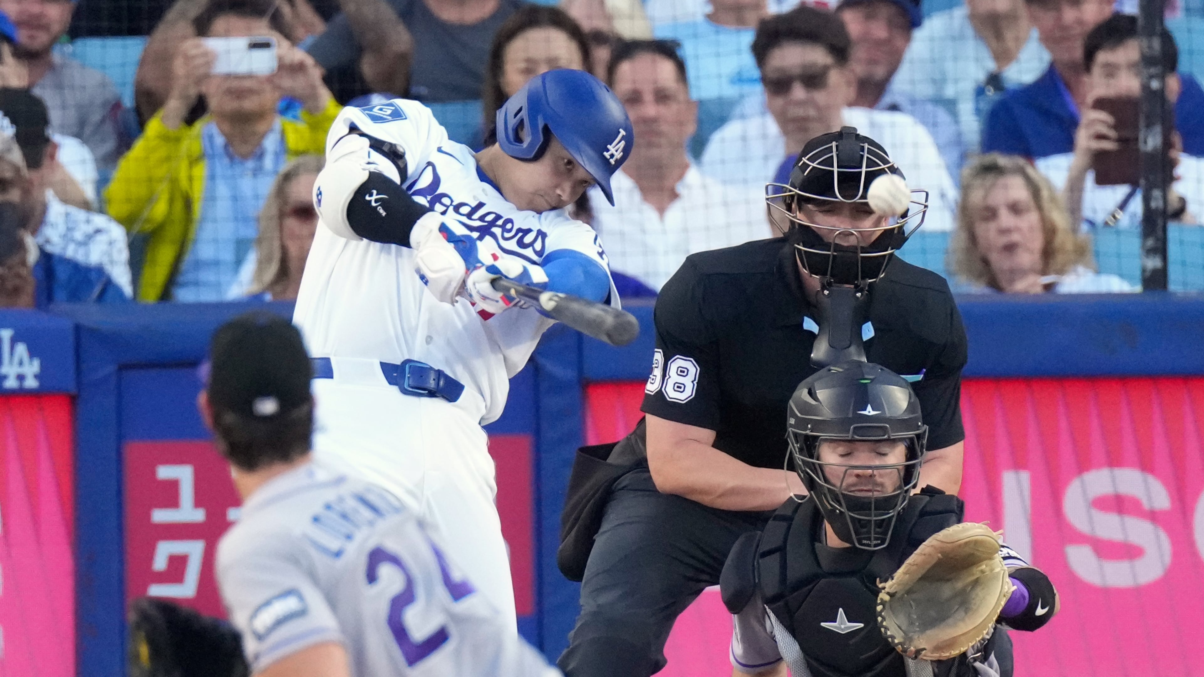 Los Angeles Dodgers' Shohei Ohtani, second from left, hits a solo home run as Colorado Rockies starting pitcher Michael Lorenzen, left, and Braxton Fulford watch during the first inning of a baseball game Tuesday, July 7, 2026, in Los Angeles. (AP Photo/Mark J. Terrill)
