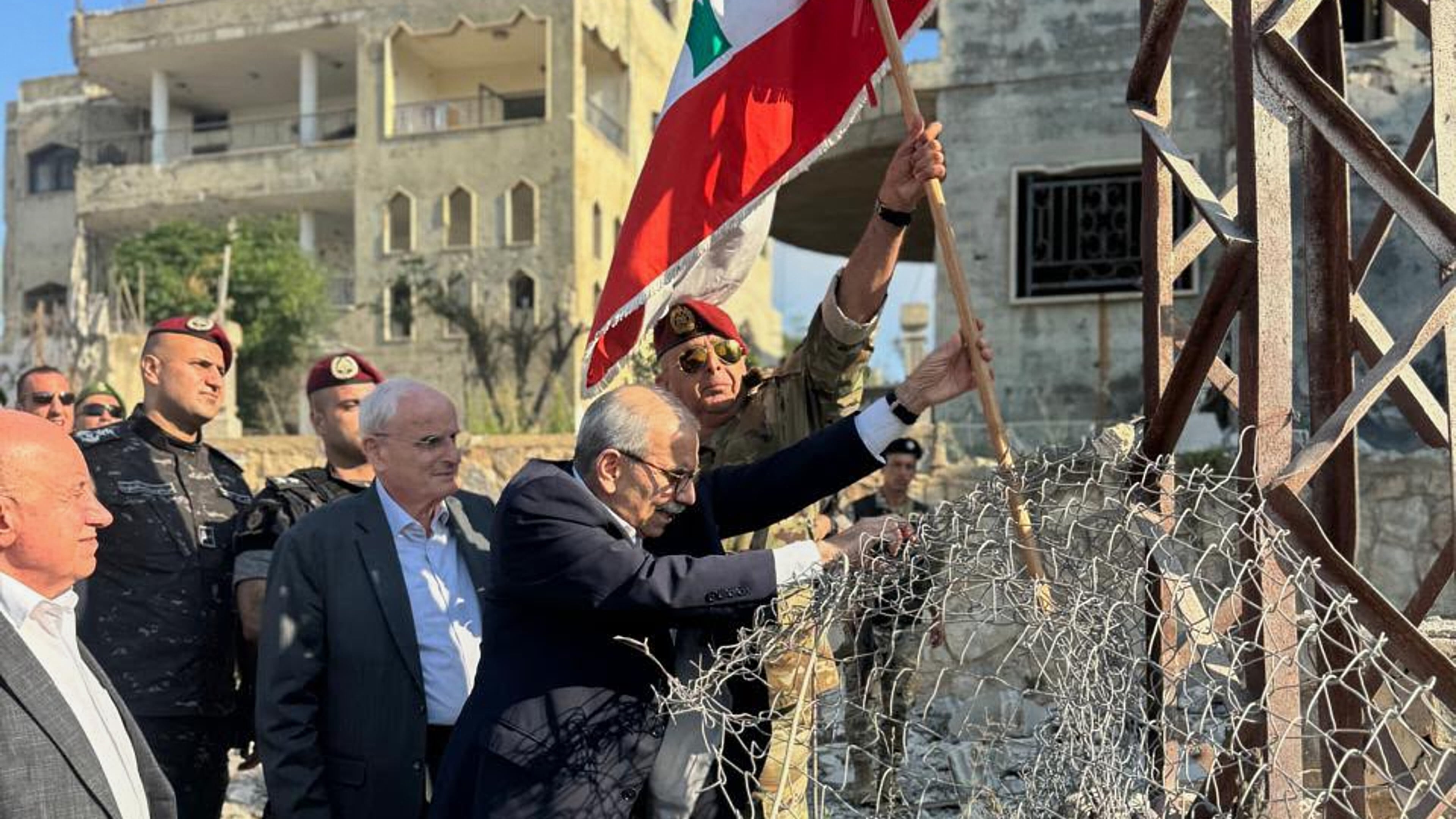 In this photo released by the Lebanese Government press office, Lebanese Prime Minister Nawaf Salam, center, raises a Lebanese flag during a visit to the southern village of Zawtar Al Gharbieh, Lebanon, Wednesday, July 22, 2026. (Lebanese Government press office via AP)
