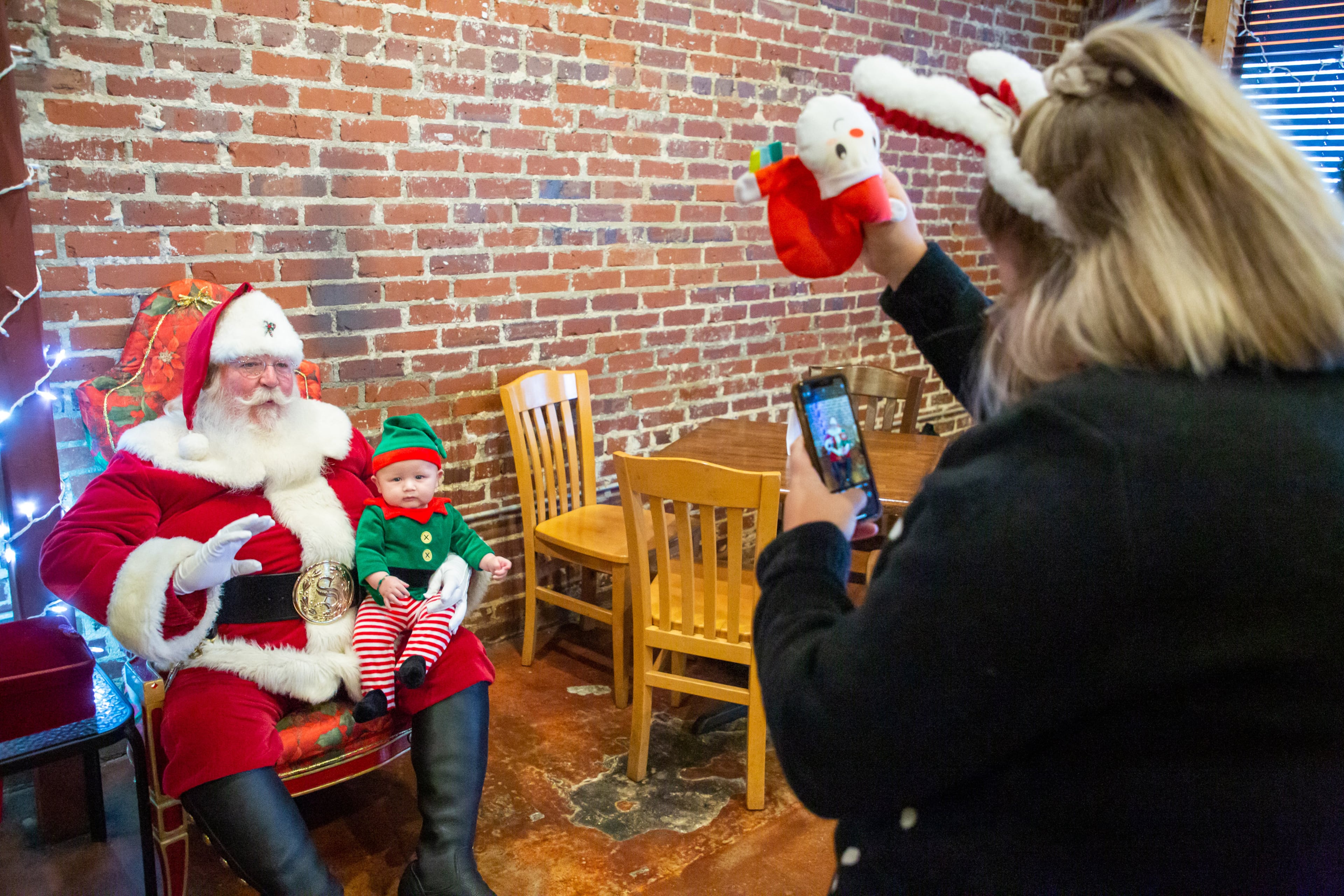 Brittany Mcleroy photographs her son Levi Aquila as he sits on Santa's lap during the Christmas Village weekend event in historic downtown Norcross on Sunday, December 5, 2021. (Photo: Steve Schaefer for The Atlanta Journal-Constitution)