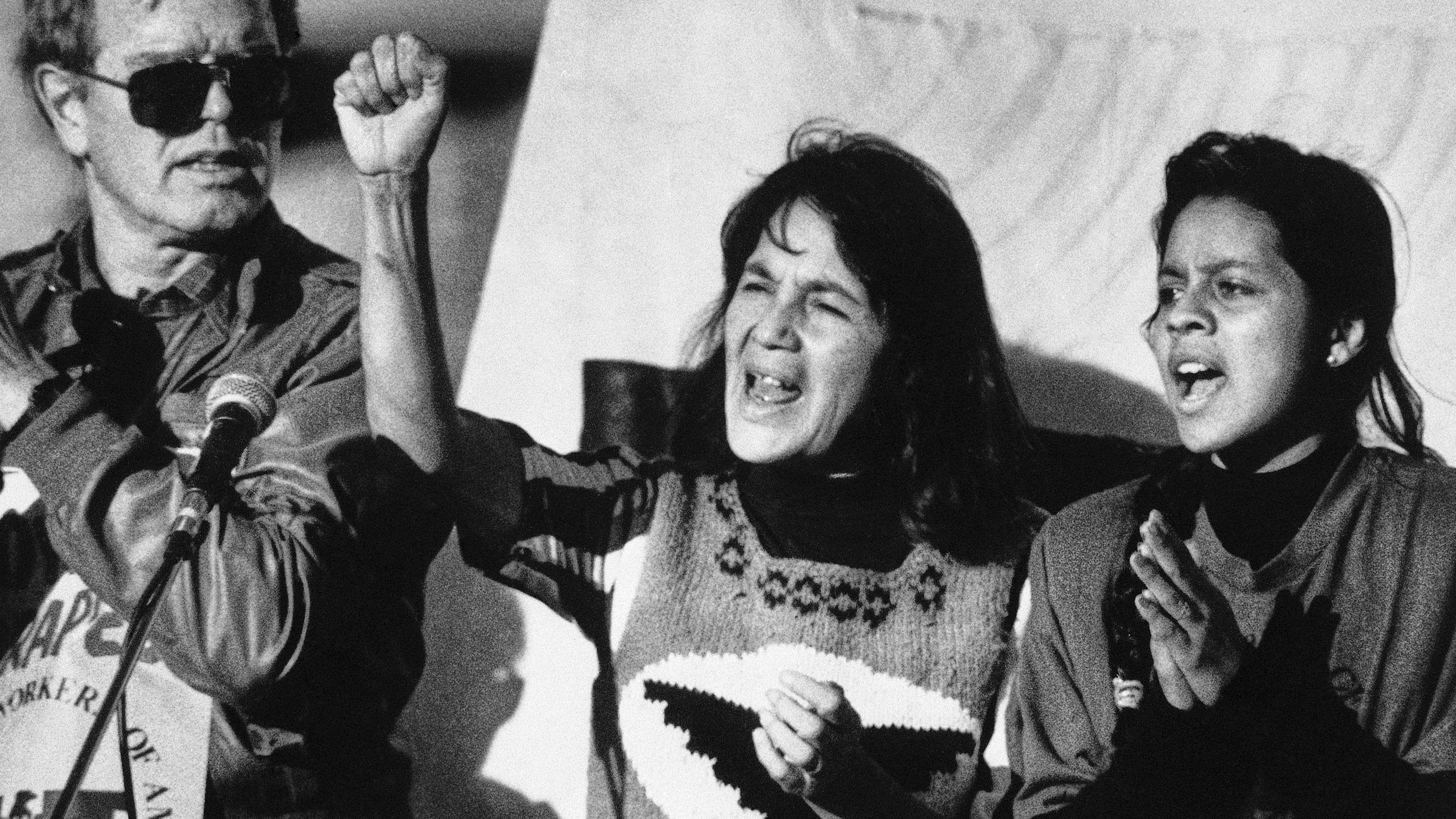 FILE - United Farm Workers leader Dolores Huerta, center, leads a rally in San Francisco's Mission District on Nov. 19, 1988, along with Howard Wallace, president of the San Francisco chapter of the UFW, left, and Maria Elena Chavez, 16, the daughter of Cesar Chavez, right, as part of a national boycott of what the UFW claims is the dangerous use of pesticides on table grapes. (AP Photo/Court Mast, File)