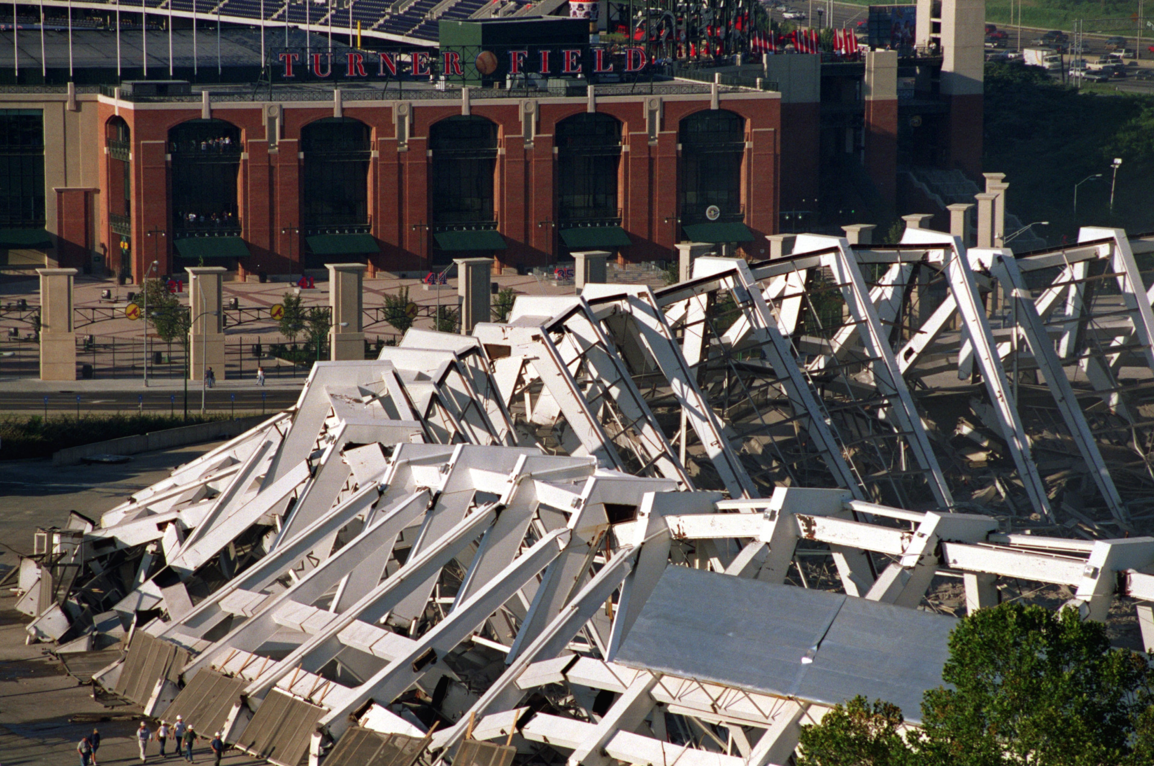 Turner Field rises up behind the collapsed remains of Atlanta Fulton County Stadium after the implosion Saturday morning, 8/2/97. Demolition crews imploded it down with a series of 1,200 successive detonations. The space will be turned into 4,000 parking spaces. (AJC Staff Photo/Kevin Keister)