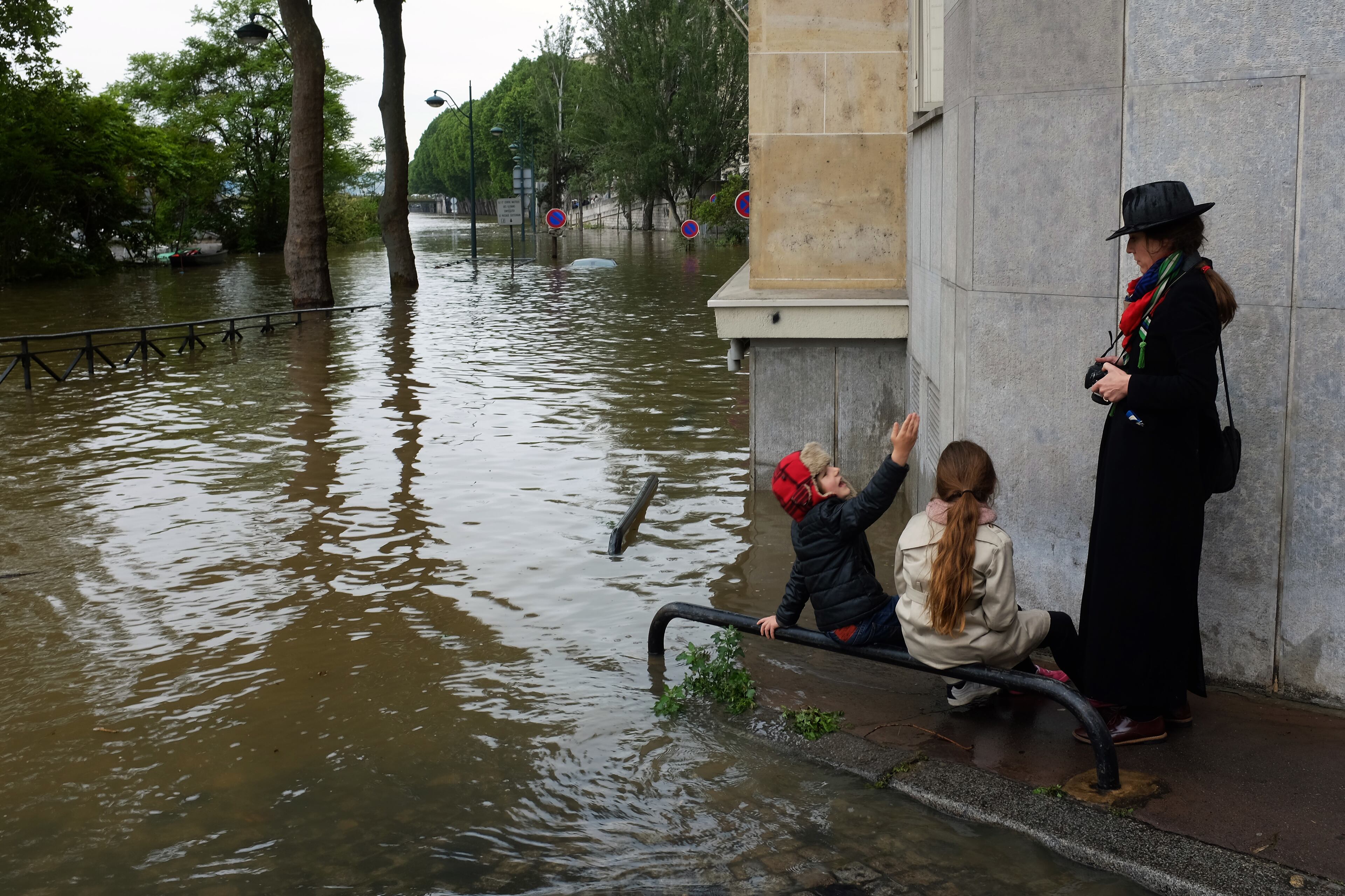 A family visits the flooded banks of the Seine river near the Eiffel Tower in Paris, France Friday June 3, 2016. Both the Louvre and Orsay museums were closed as the Seine, which officials said was at its highest level in nearly 35 years, was expected to peak sometime later Friday. (AP Photo/Jerome Delay)