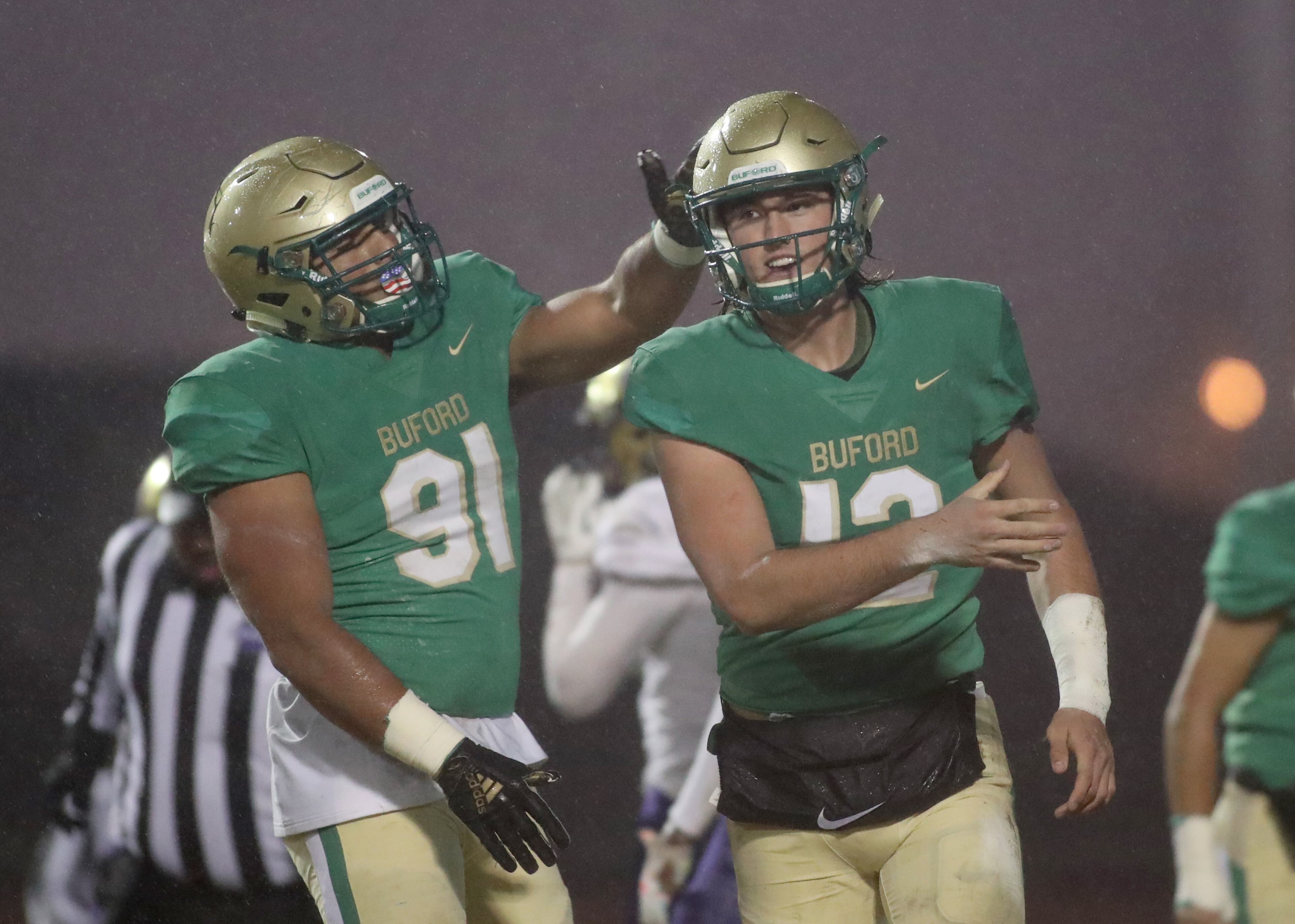 November 23, 2018 - Buford, Ga: Buford quarterback Aaron McLaughlin (12) celebrates his rushing touchdown with tight end Dom Maggio in the first half against Bainbridge at Buford High School Friday, November 23, 2018, in Buford, Ga. This is the quarter finals of the Class 5A state playoffs. (JASON GETZ/SPECIAL TO THE AJC)