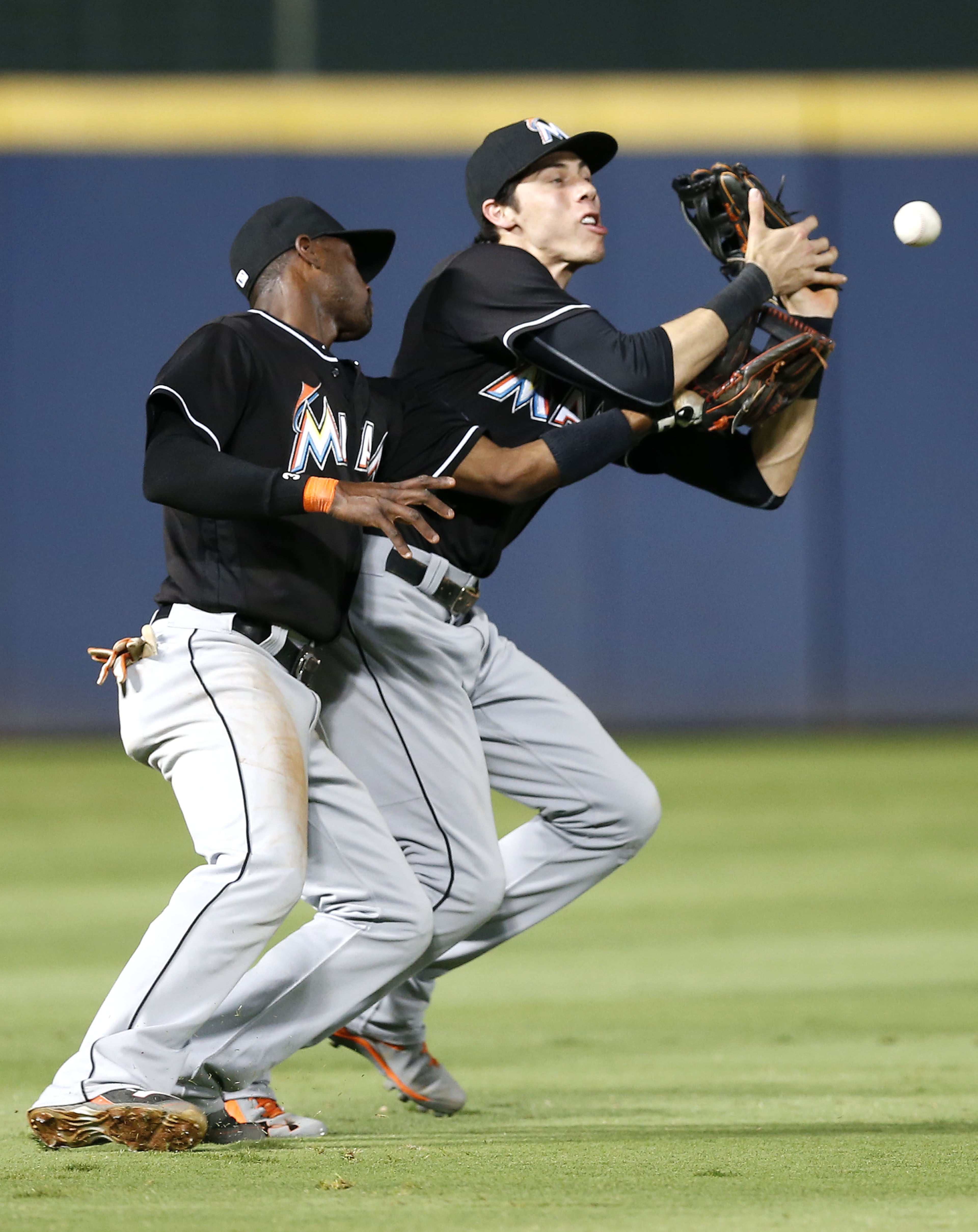 ATLANTA, GA - JULY 01: Left fielder Christian Yelich #21 and shortstop Adeiny Hechavarria #3 of the Miami Marlins collide and drop the ball hit by Freddie Freeman #5 of the Atlanta Braves (not pictured) in the tenth inning during the game at Turner Field on July 1, 2016 in Atlanta, Georgia. (Photo by Mike Zarrilli/Getty Images)