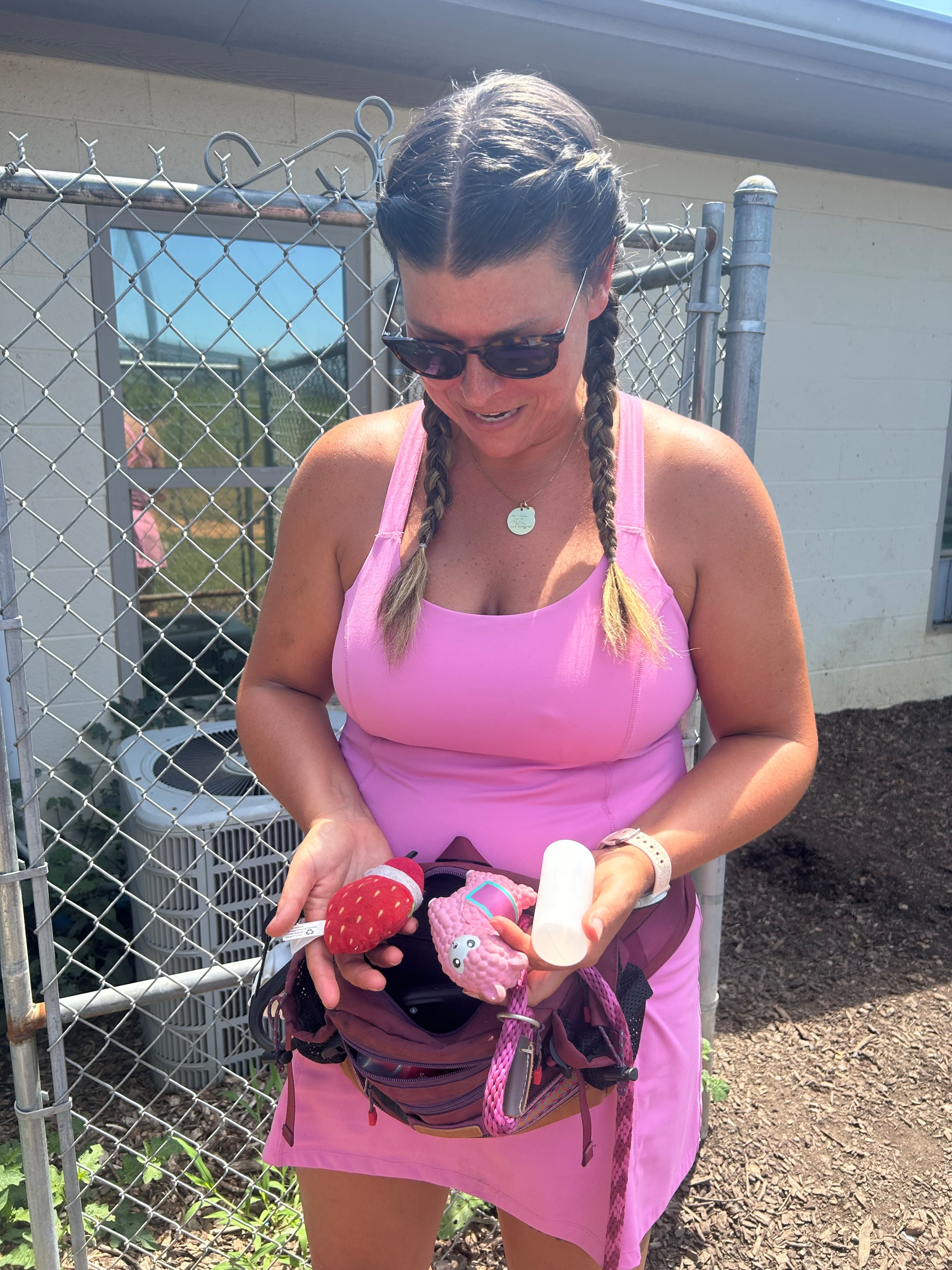 Katie Ceraso holds out three of the squeaky toys she always keeps in her fanny pack. She said the most popular toy is the pink llama. (Olivia Wakim/AJC)
