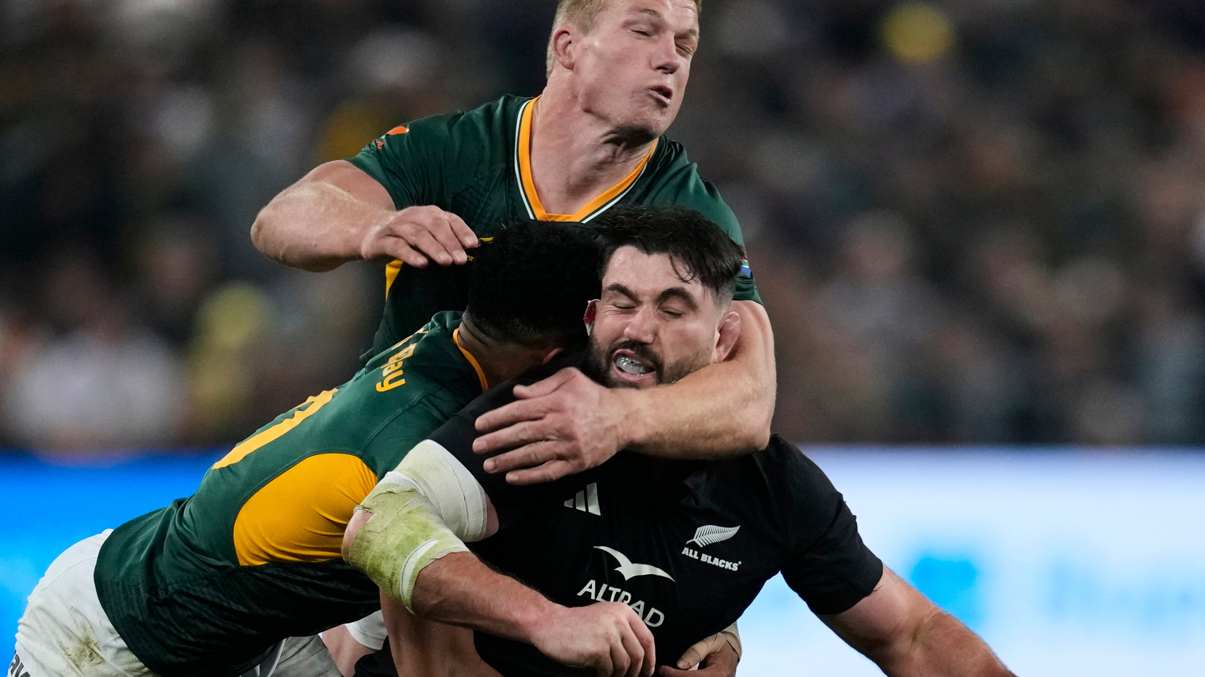 New Zealand's Luke Jacobson, right, is tackled by South Africa's Sacha Feinberg-Mngomezulu, left, and his teammate Pieter-Steph du Toit, during a third international test rugby match between South Africa and New Zealand, in Johannesburg, South Africa, Saturday, Sept. 5, 2026. (AP Photo/Themba Hadebe)