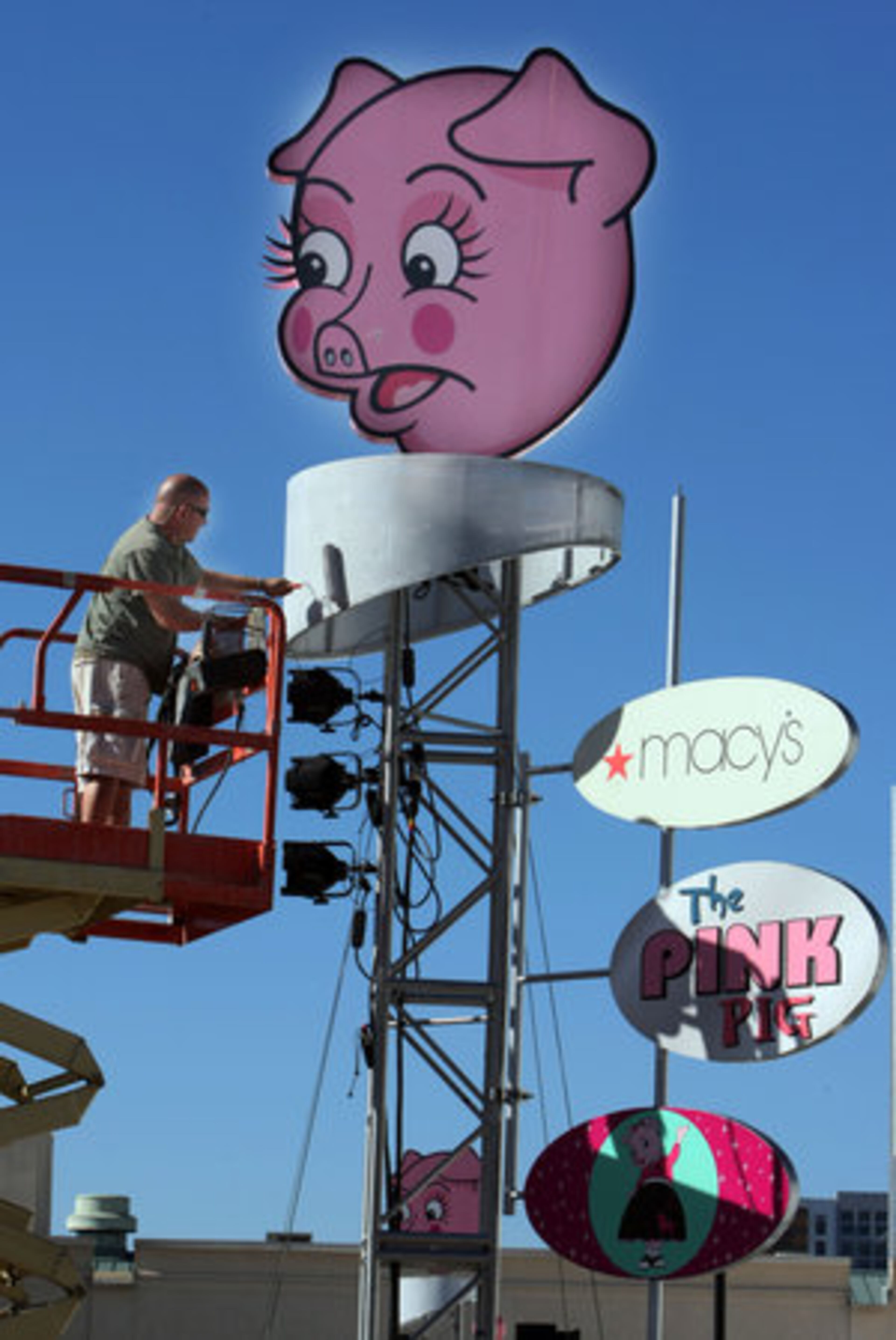 Ian Doby puts a fresh coat of paint on the outdoor sign. For more information, go to www.macys.com/campaign/pinkpig/home.jsp.