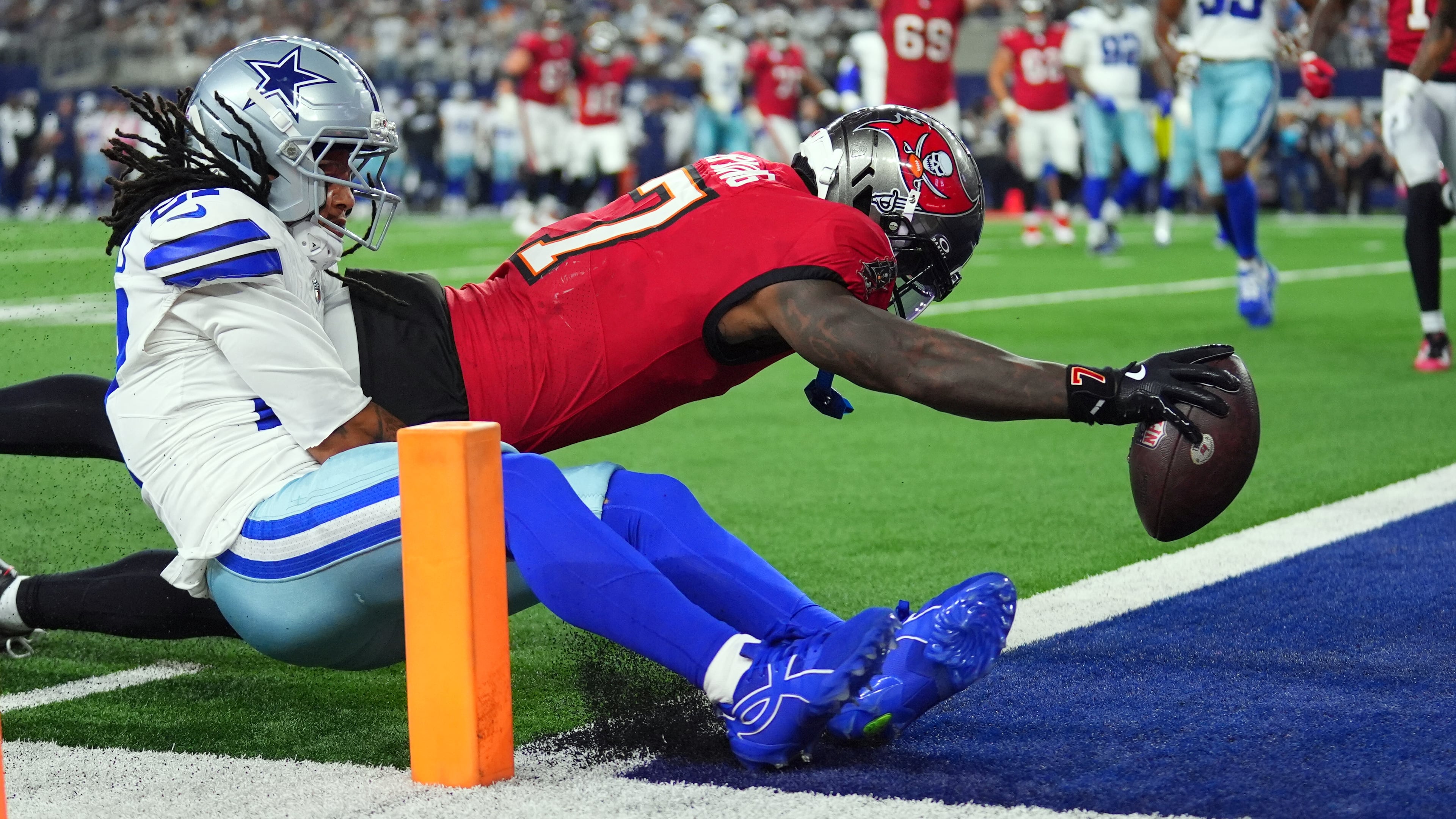 Tampa Bay Buccaneers running back Bucky Irving (7) dives past Dallas Cowboys defensive back Reddy Steward (27) for a touchdown in the first half of an NFL football game in Arlington, Texas on Thursday, Oct. 8, 2026. (AP Photo/Julio Cortez)