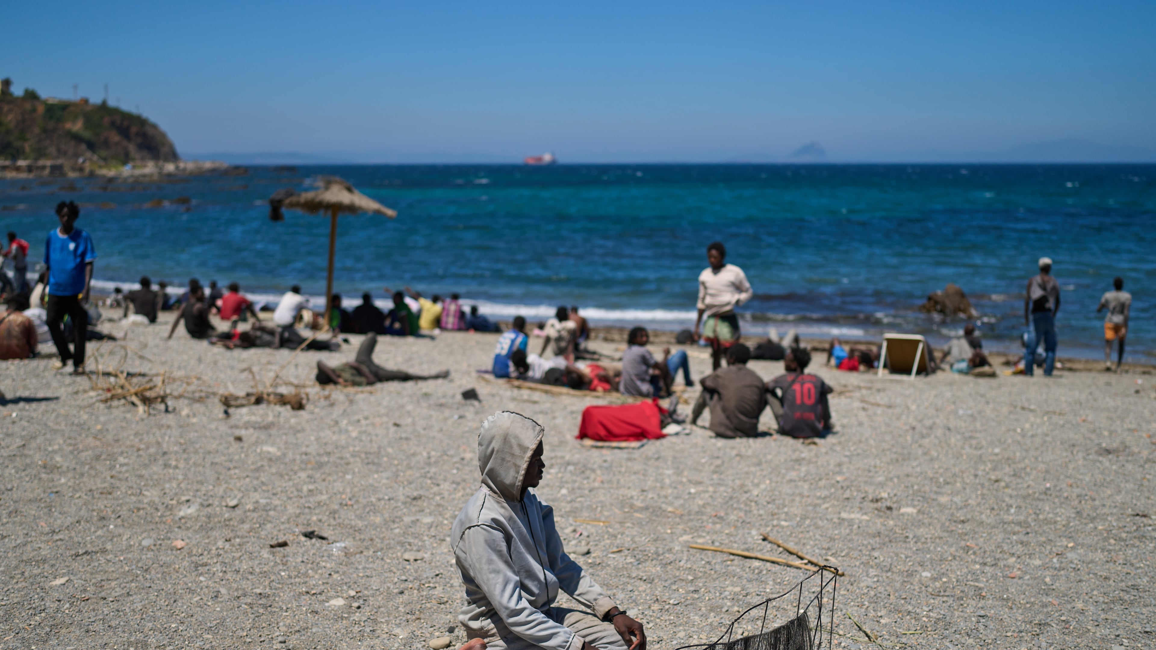 A migrant who crossed into Spain from Morocco prays on a beach in the Spanish enclave of Ceuta, Sunday, Aug. 2, 2026. (AP Photo/Bernat Armangue)