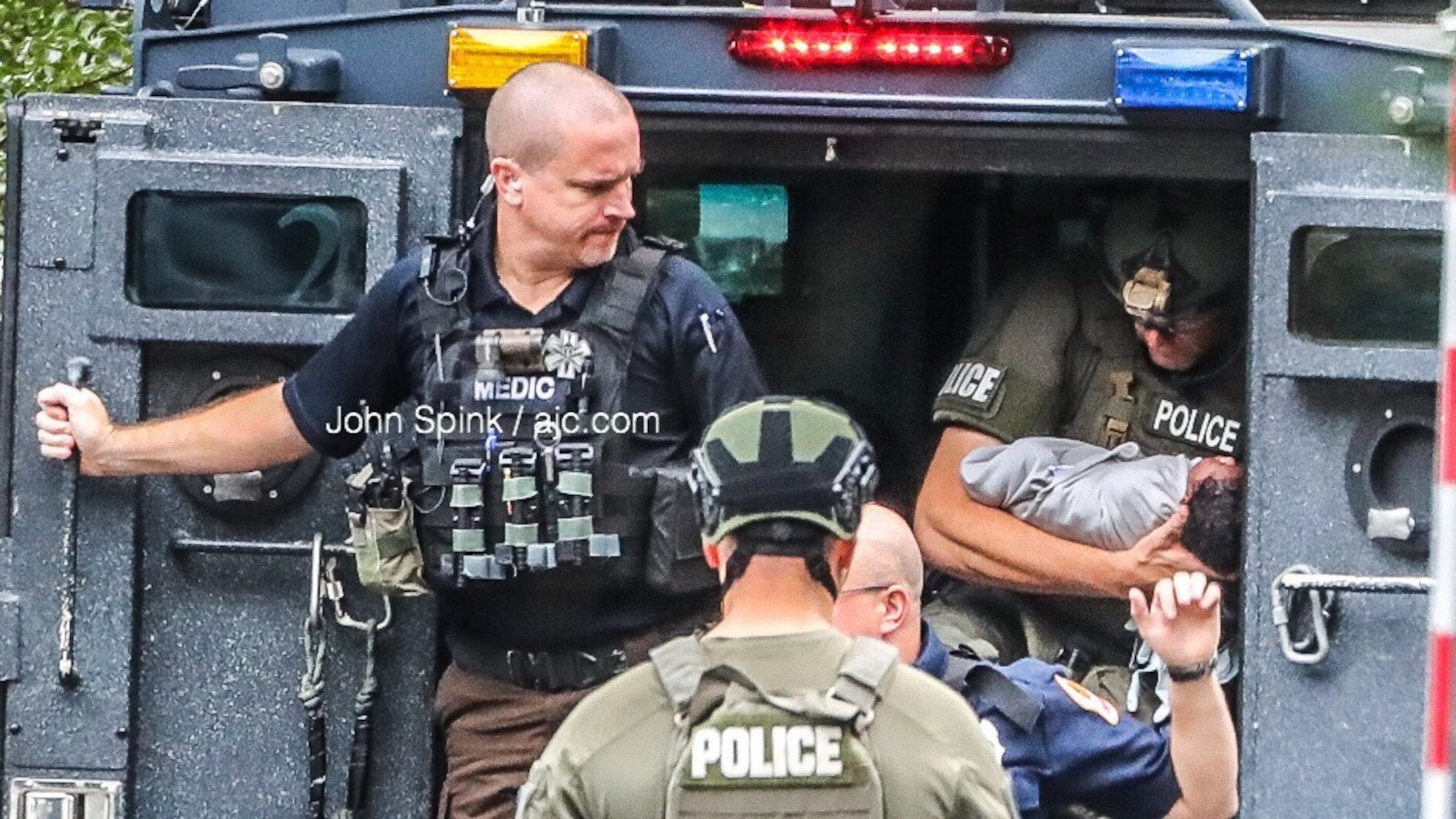 A SWAT officer cradles a baby removed from a Gwinnett County apartment during a standoff with the child's father Thursday morning.