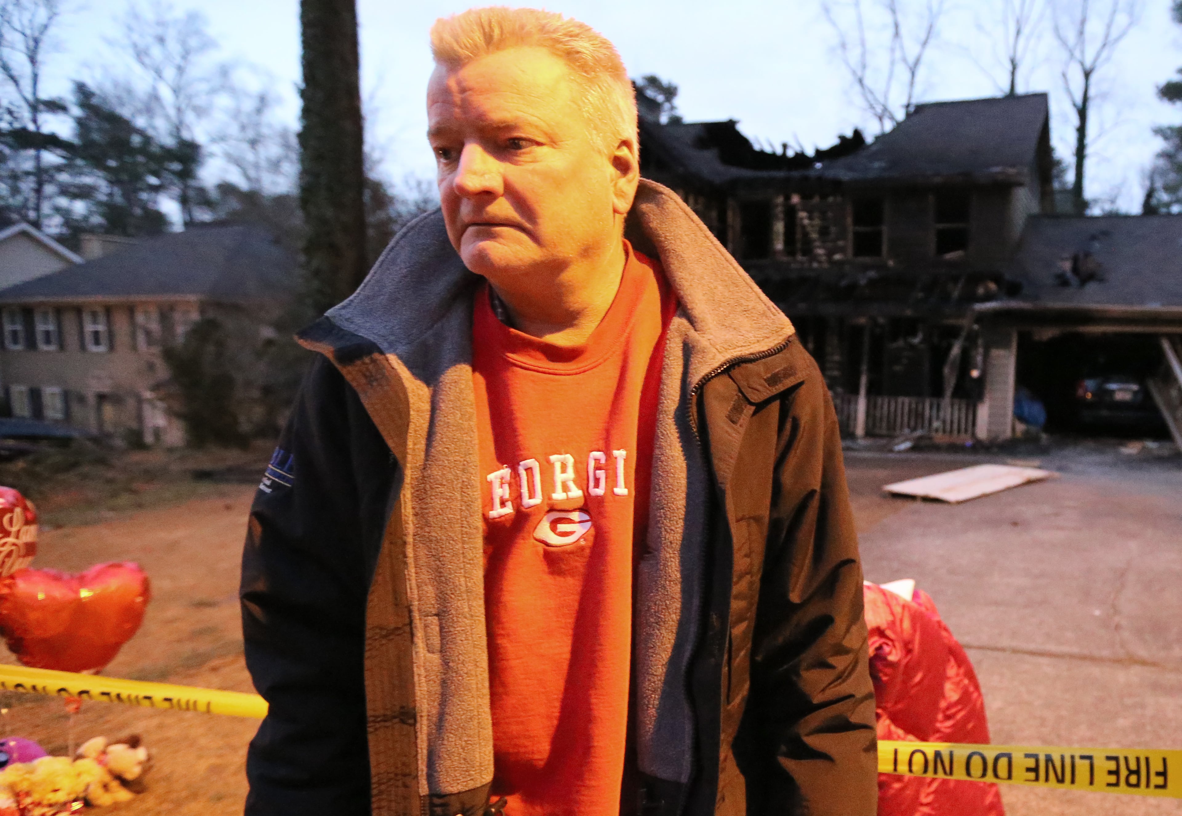 Brent Patterson stands in front of his burned-out Tucker home on Wednesday night Feb. 10, 2016, following a Tuesday night fire that killed his wife and two daughters. Ben Gray / bgray@ajc.com