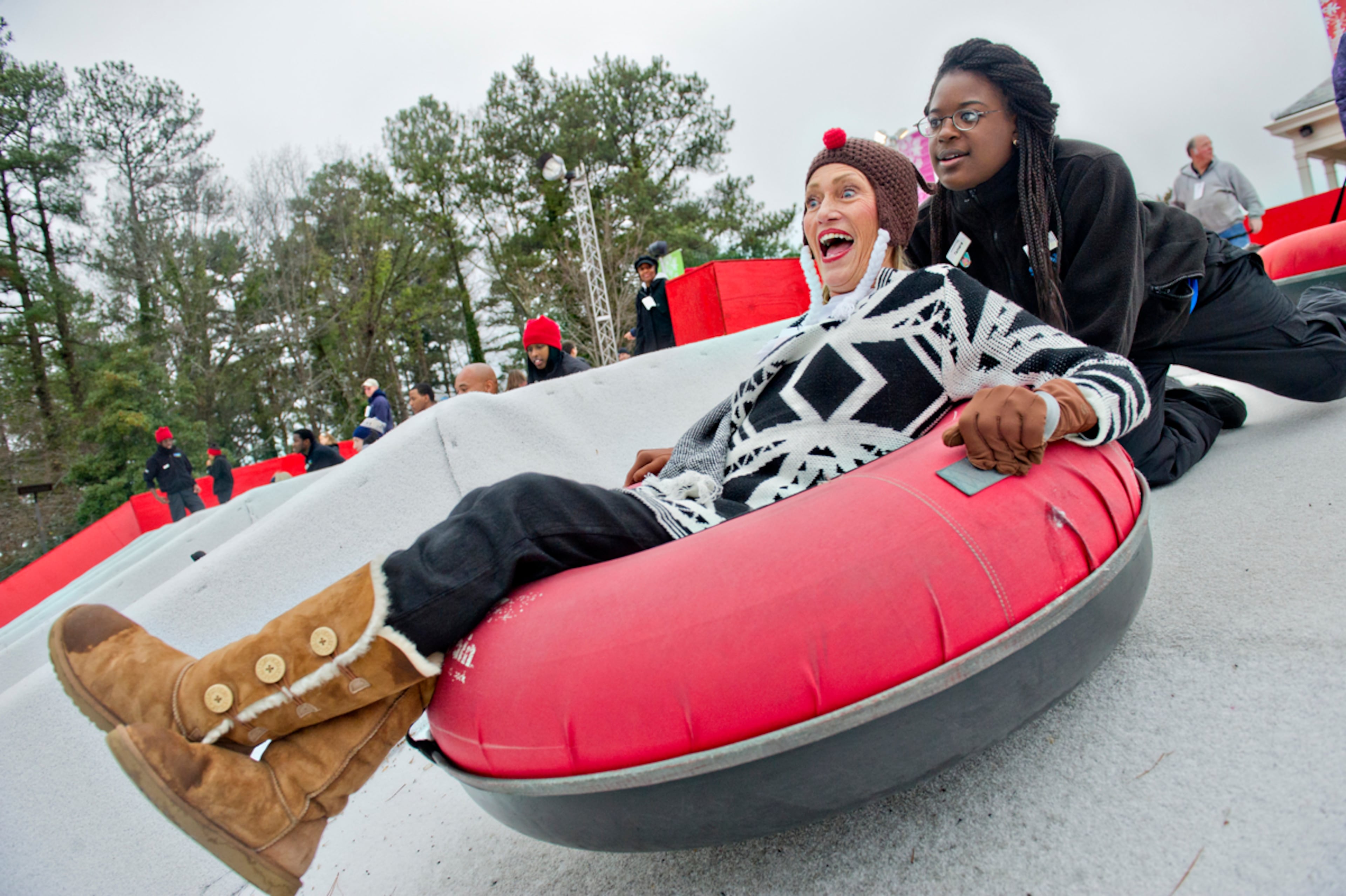 SNOW MOUNTAIN--December 21, 2014 Stone Mountain - Vicki Everage (left) screams as Tamara Mitchell pushes her tube down the hill during Snow Mountain at Stone Mountain Park on Sunday, December 21, 2014. This is the seventh season that the main lawn at the park has been transformed into a winter wonderland. JONATHAN PHILLIPS / SPECIAL