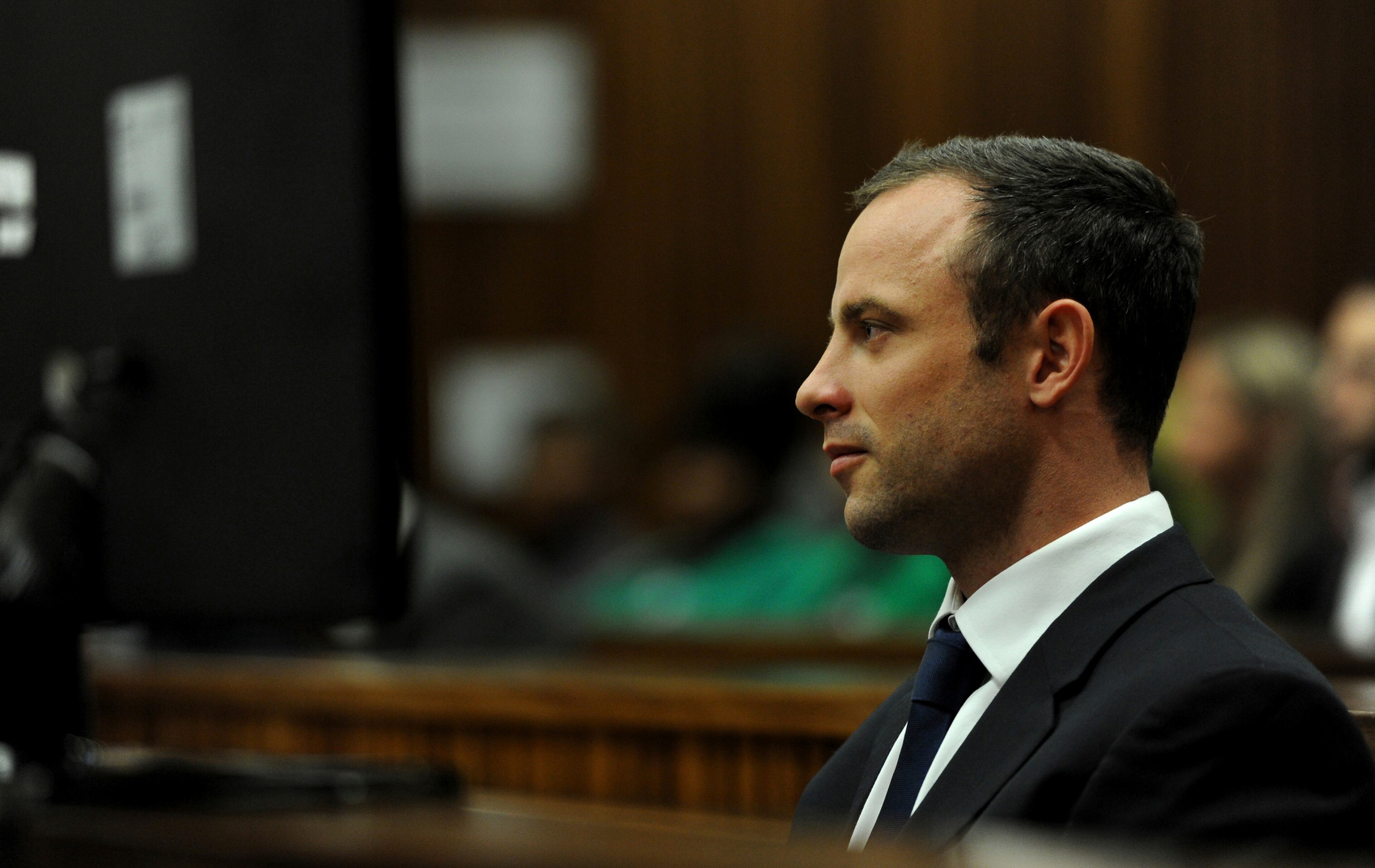 Oscar Pistorius sits in the dock as he listens to cross questioning about the events surrounding the shooting death of his girlfriend Reeva Steenkamp, in court during the second week of his trial in Pretoria, South Africa, Wedensday, March 12, 2014. Pistorius is charged with the shooting death of Steenkamp, on Valentines Day in 2013. (AP Photo/Werner Beukes, Pool)