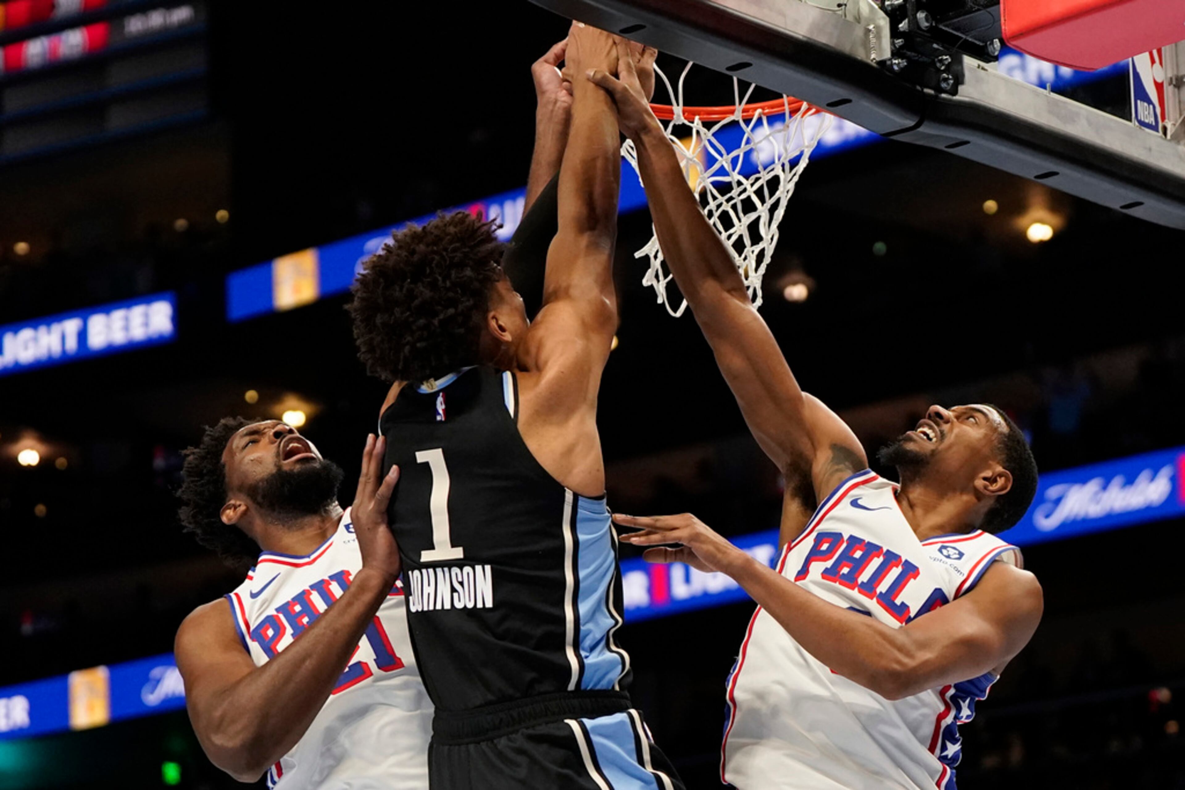 Atlanta Hawks forward Jalen Johnson (1) heads to the rim against Philadelphia 76ers center Joel Embiid (21) and guard Tyrese Maxey (0) during the first half of an In-Season Tournament NBA basketball game, Friday, Nov. 17, 2023, in Atlanta. (AP Photo/Mike Stewart)