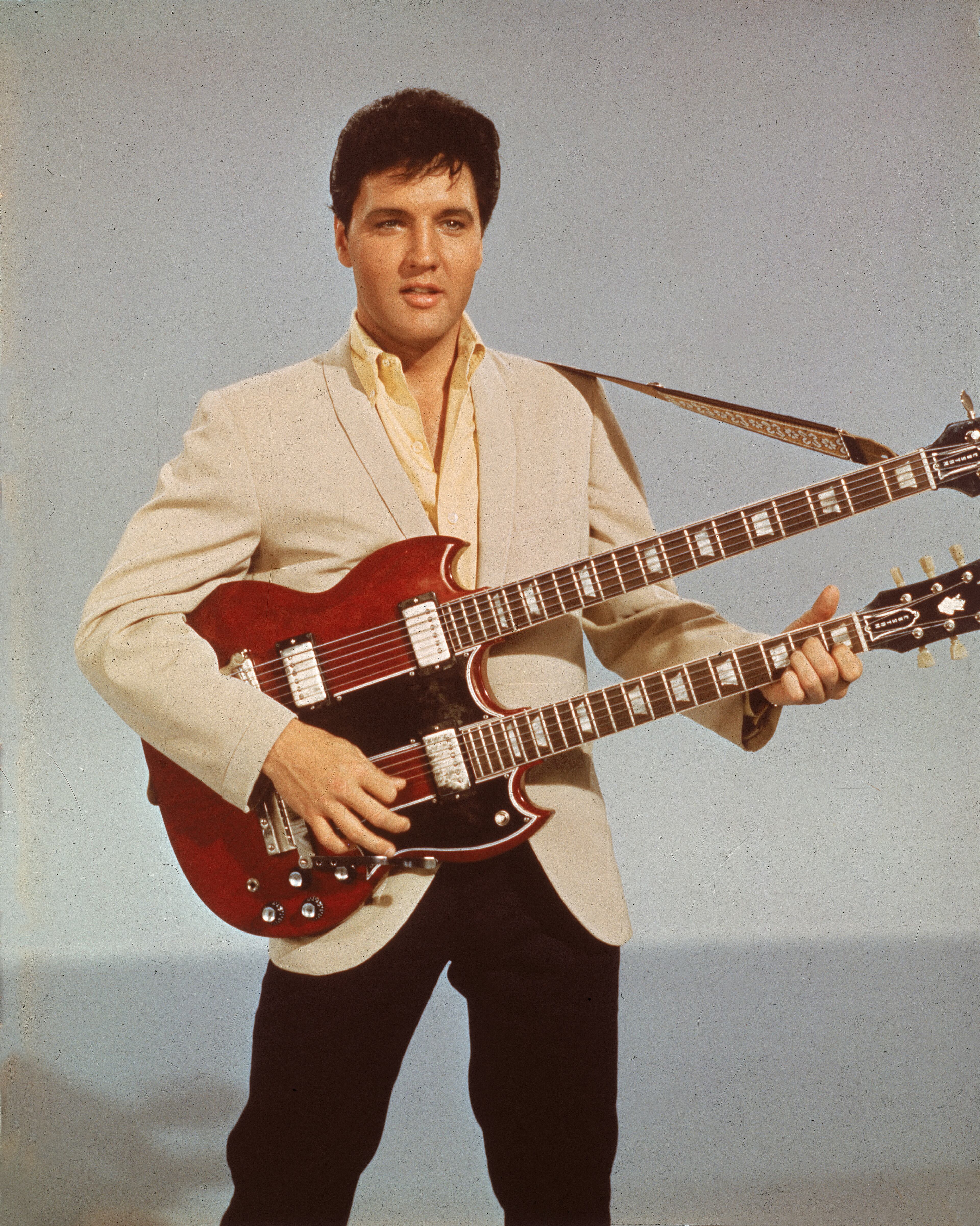 Portrait of American singer and actor Elvis Presley (1935-1977) as he holds a 12-string guitar, mid-1950s.