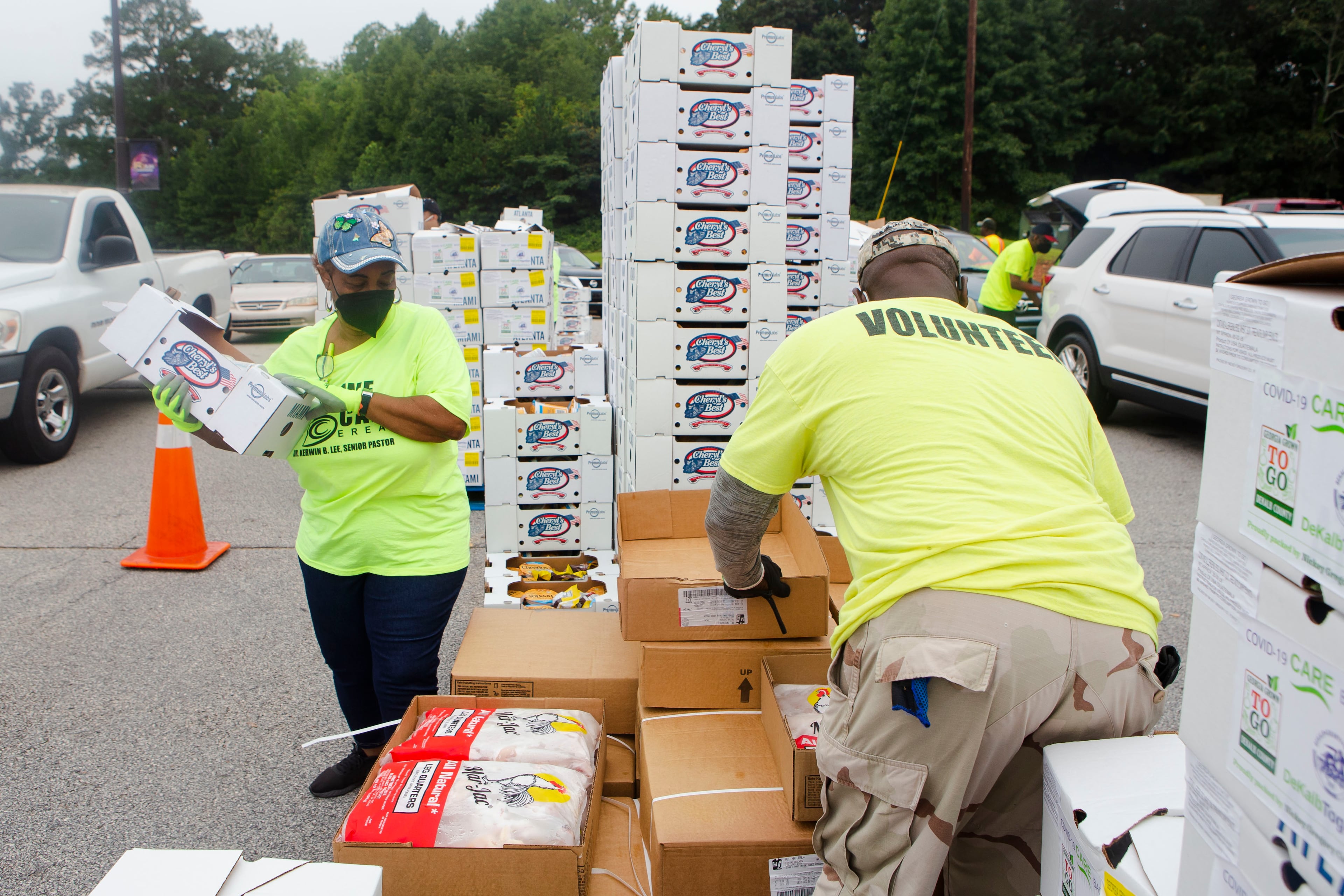 Valerie Henry (left) and Bernard Williams (right) volunteer during a food giveaway event at Berean Christian Church on Saturday, August 27, 2022, in Stone Mountain, Georgia. The free food was paid for using federal COVID-19 stimulus funds, and was distributed at churches throughout DeKalb County. CHRISTINA MATACOTTA FOR THE ATLANTA JOURNAL-CONSTITUTION.