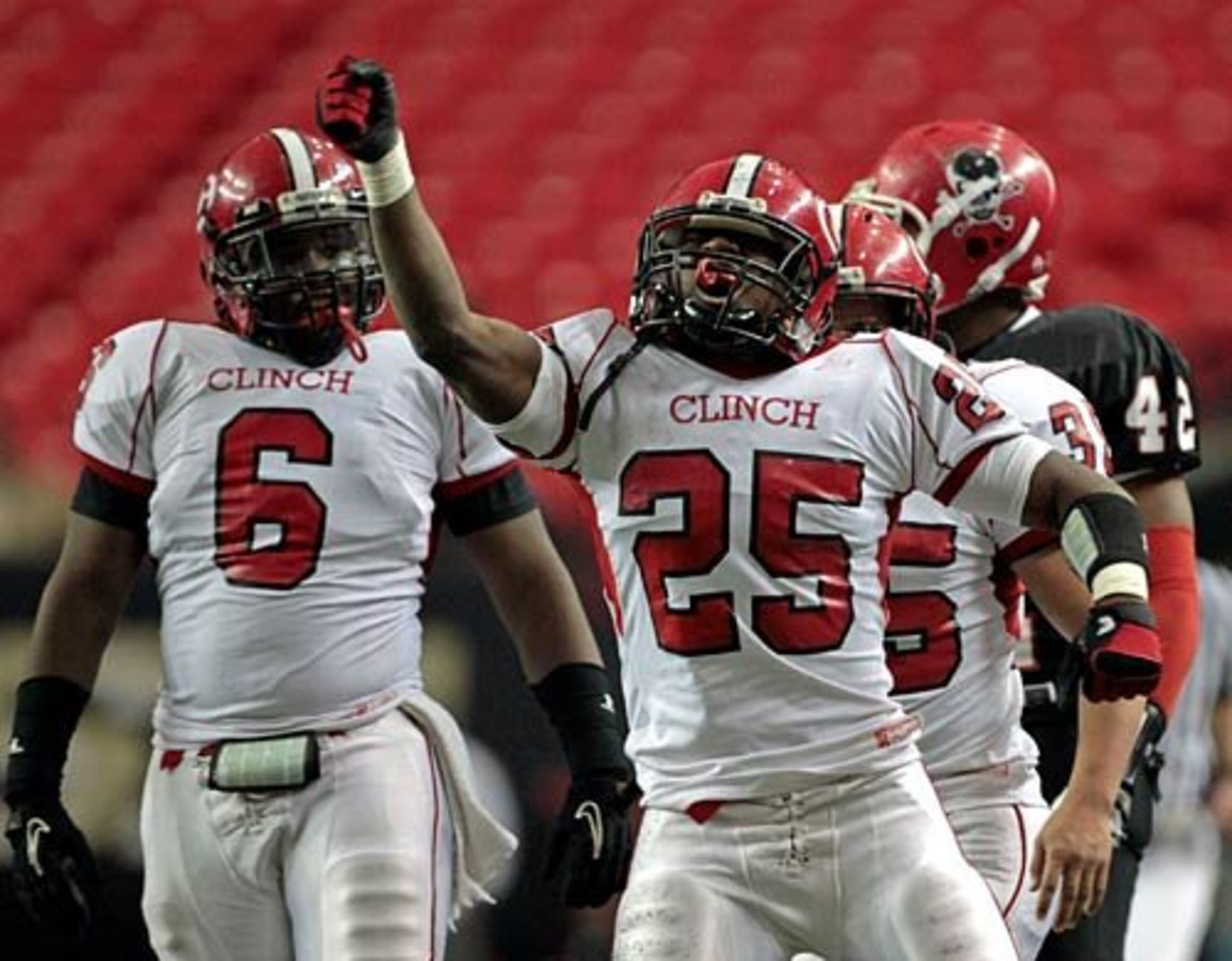 Clinch County defensive back Anthony McNeil (25) celebrates a defensive play with linebacker Trey Richardson in the first half.