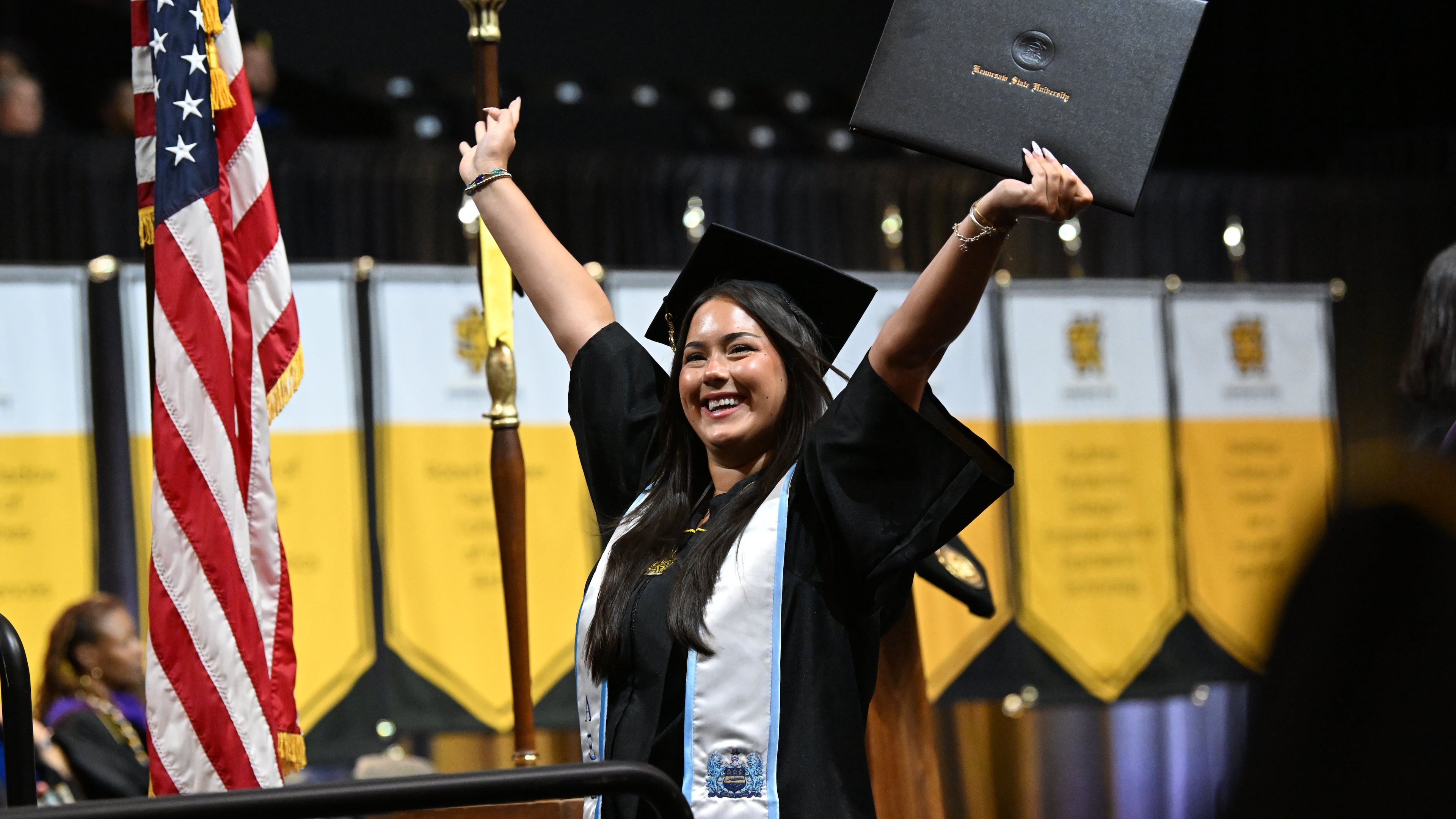 Kennesaw State University graduate Stella Roman cheers after receiving her diploma during the spring 2026 commencement at the KSU Convocation Center on Wednesday, May 13, 2026. Georgia's public universities, including KSU, could soon offer 90-hour degrees instead of the traditional 120 hours. (Hyosub Shin/AJC)
