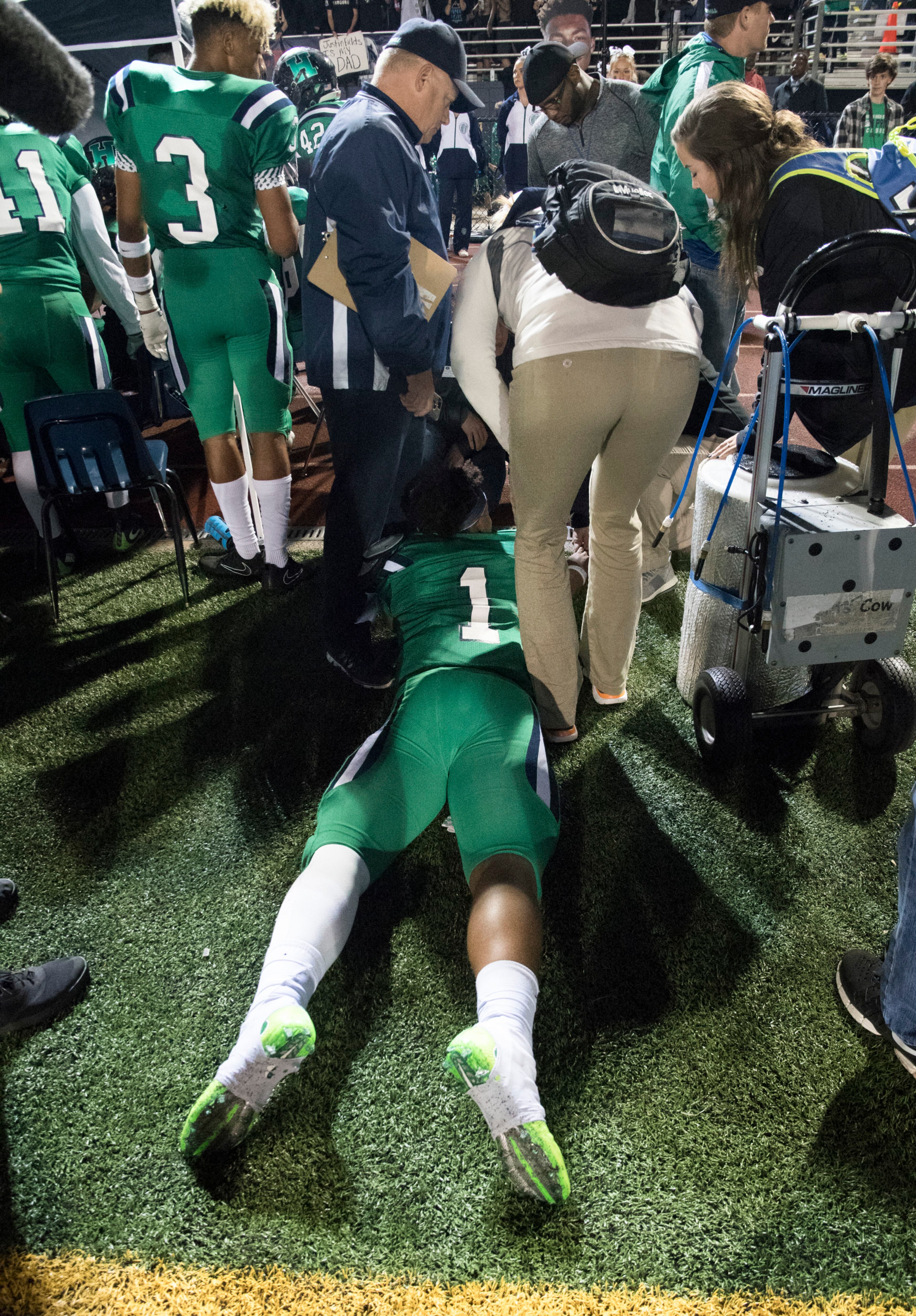 Harrison quarterback Justin Fields is tended to on the sideline after running off the field and laying down during the second half of a high school football game against Dalton on Thursday, Oct. 19, 2017, in Kennesaw, Ga. (Special to the Atlanta Journal-Constitution, John Amis )
