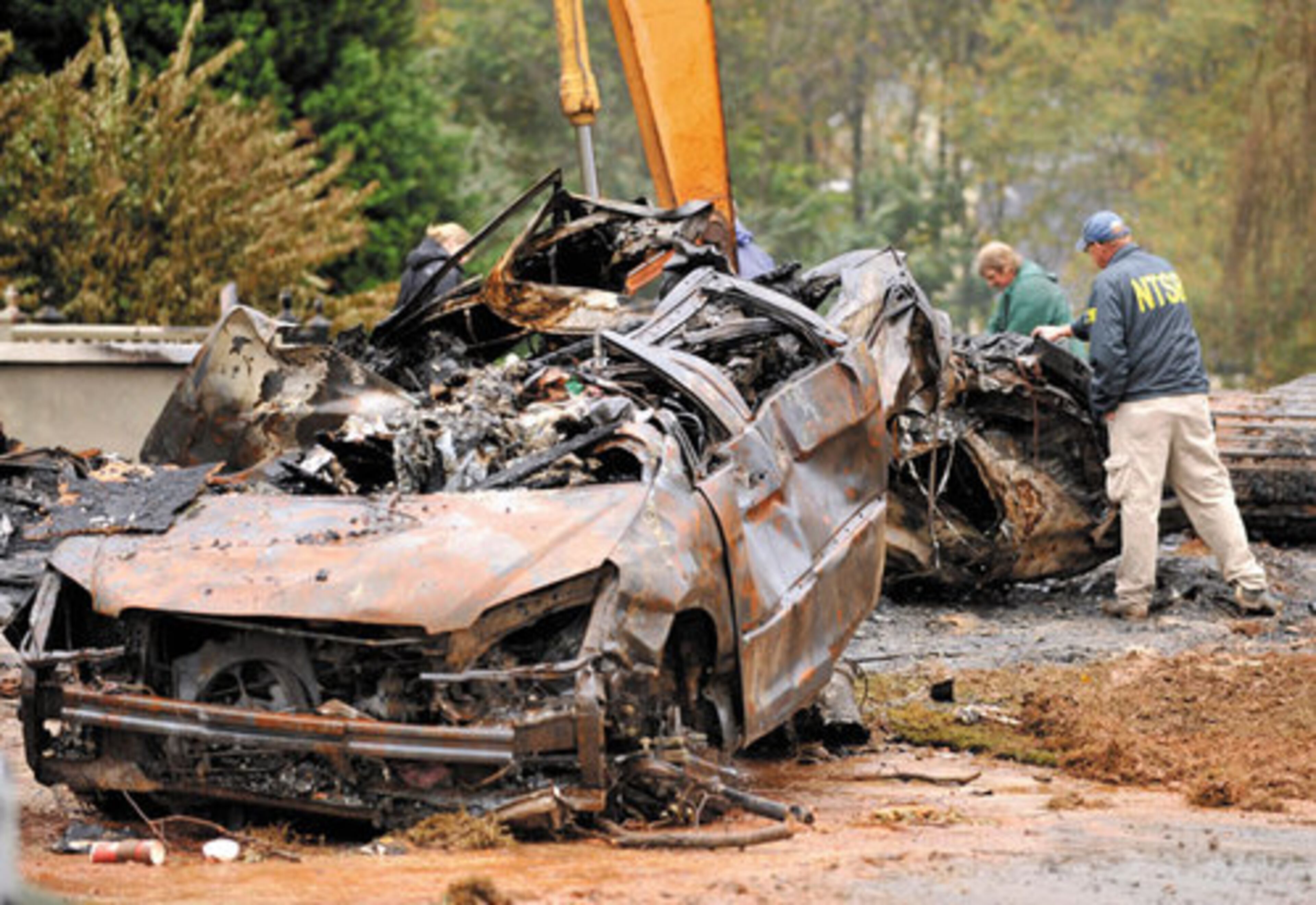 The plane slammed into a house killing the pilot and a woman inside the home. This car at the house was burned.