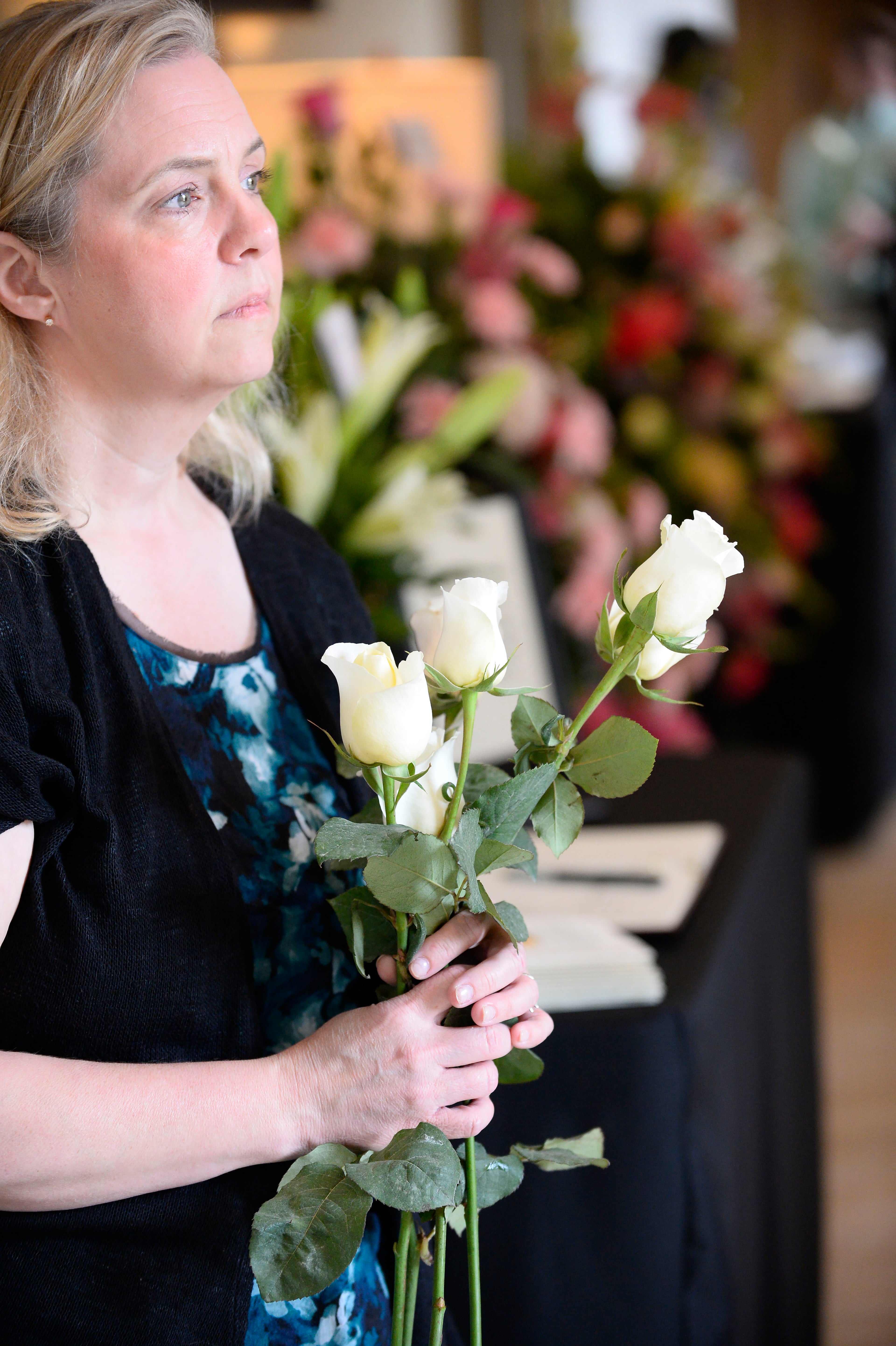 Jeannie Mosier, a family friend, holds white roses during a celebration of life for Catherine "McKay" Pittman, 21, one of five Georgia Southern University nursing students who were killed in an I-16 highway crash earlier in the week, during services at the First Baptist Church of Alpharetta on Saturday, April 25, 2015, in Alpharetta, Ga. David Tulis / AJC Special