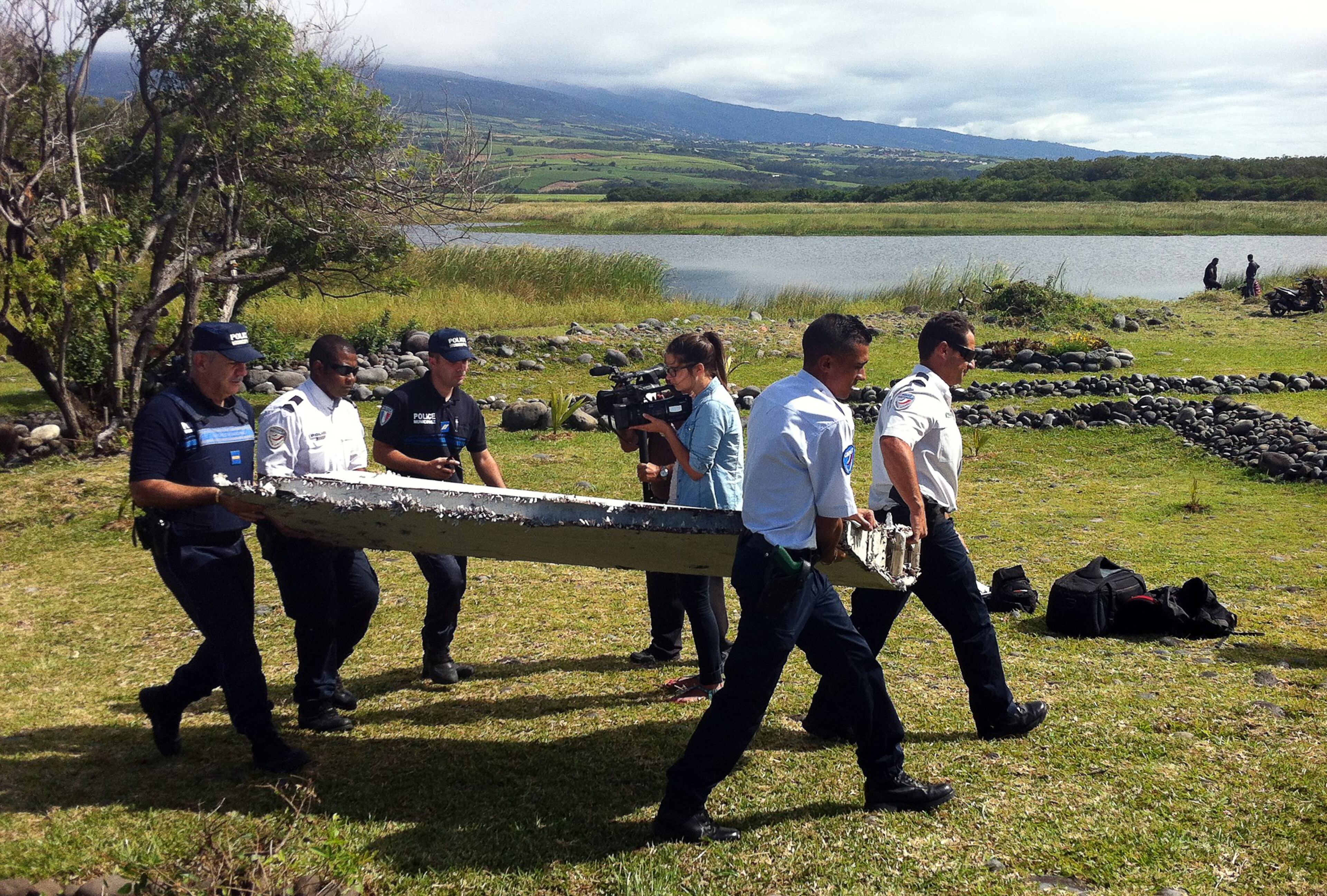 Police carry a piece of debris from an unidentified aircraft found in the coastal area of Saint-Andre de la Reunion, in the east of the French Indian Ocean island of La Reunion, on July 29, 2015. The two-metre-long debris, which appears to be a piece of a wing, was found by employees of an association cleaning the area and handed over to the air transport brigade of the French gendarmerie (BGTA), who have opened an investigation. An air safety expert did not exclude it could be a part of the Malaysia Airlines flight MH370, which went missing in the Indian Ocean on March 8, 2014. (Photo: YANNICK PITOU/AFP/Getty Images)