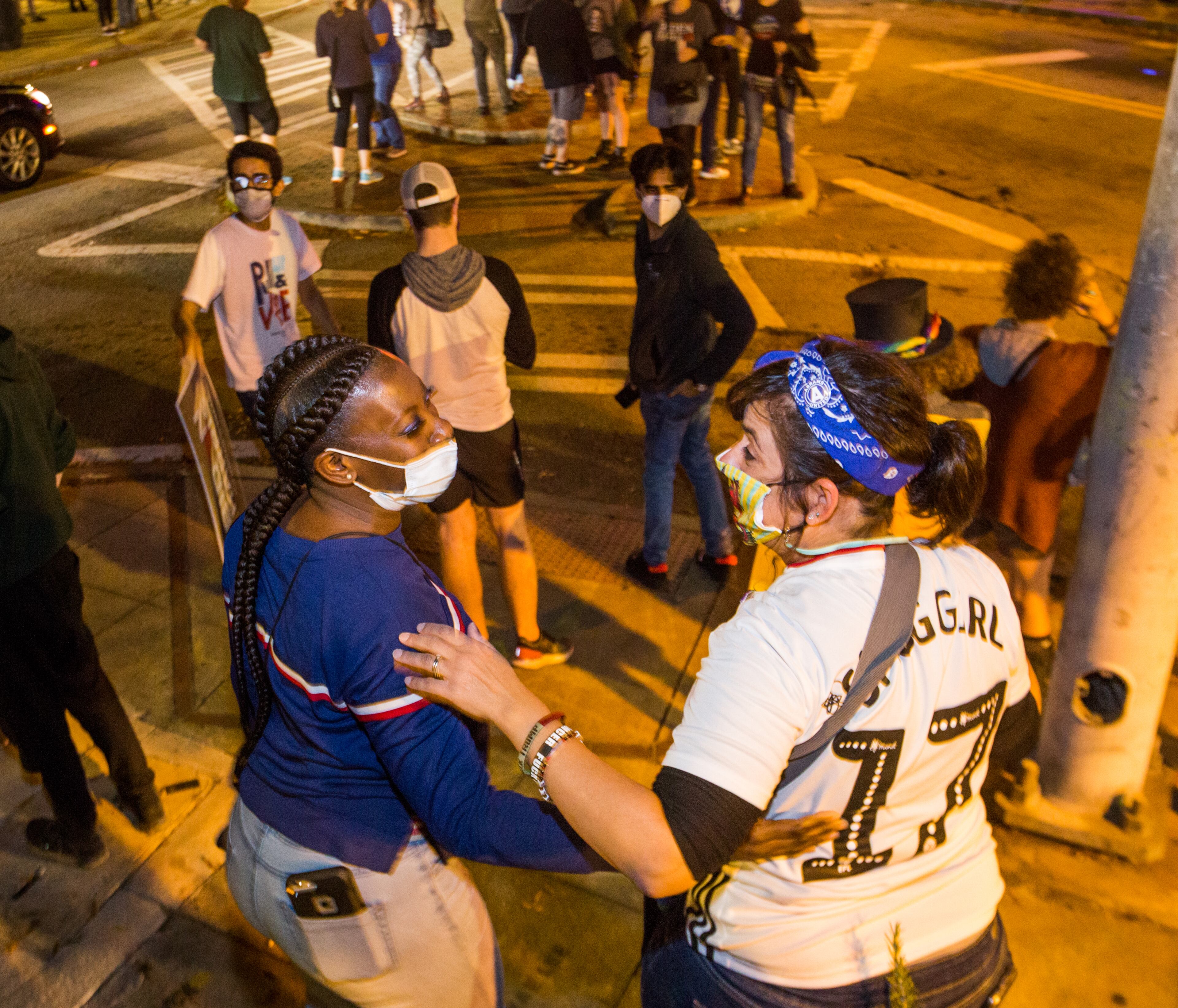 Sheila Holt, left, and Terri Harrington, right, embrace in East Atlanta as election results become more clear and celebrations for President-Elect Joe Biden and VP Kamala Harris begin on Saturday, Nov 7, 2020. (Jenni Girtman for The Atlanta Journal-Constitution)