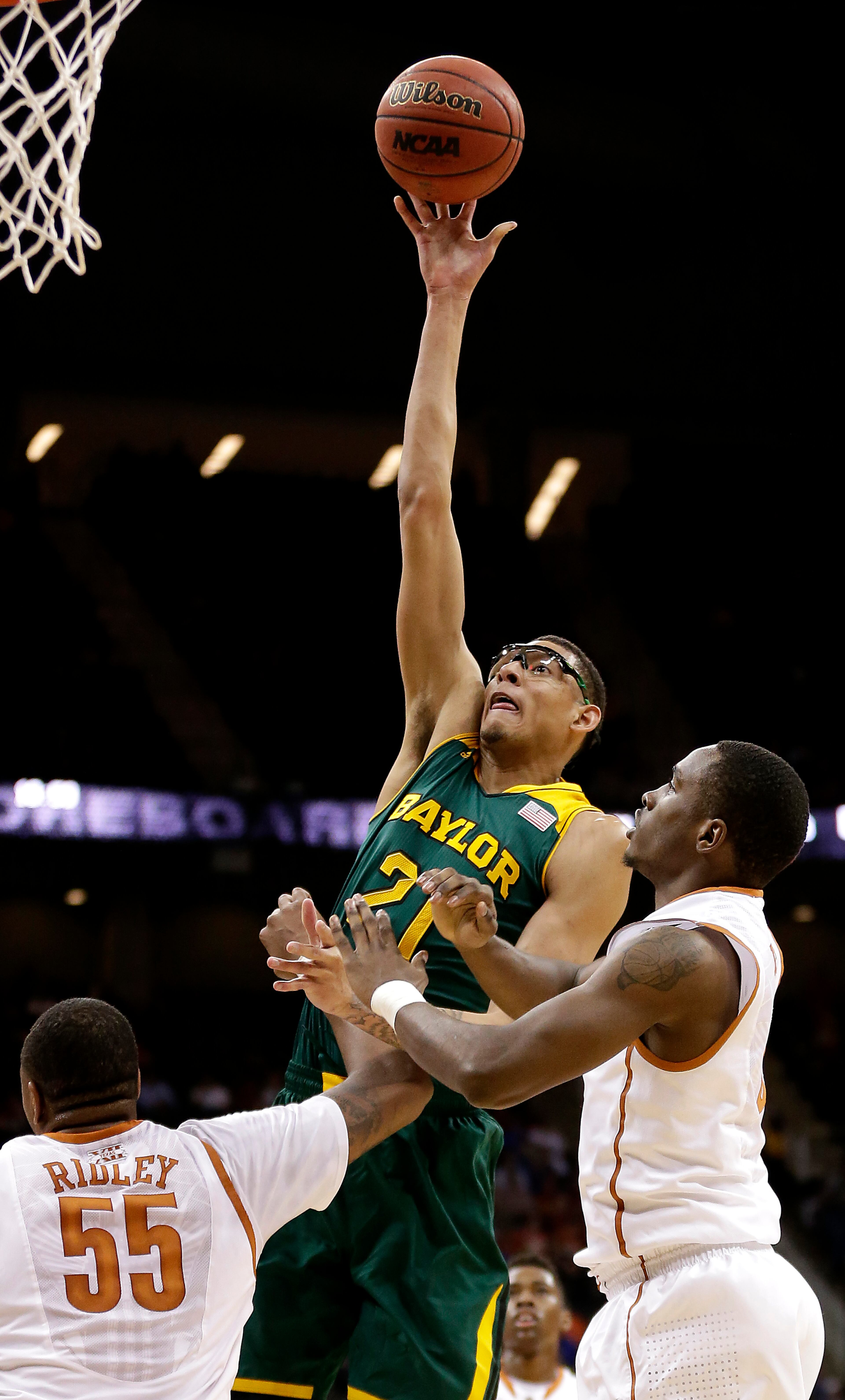 Baylor's Isaiah Austin (21) shoots over Texas' Cameron Ridley (55) and Kendal Yancy during the first half of an NCAA college basketball game in the semifinals of the Big 12 Conference tournament on Friday, March 14, 2014, in Kansas City, Mo.