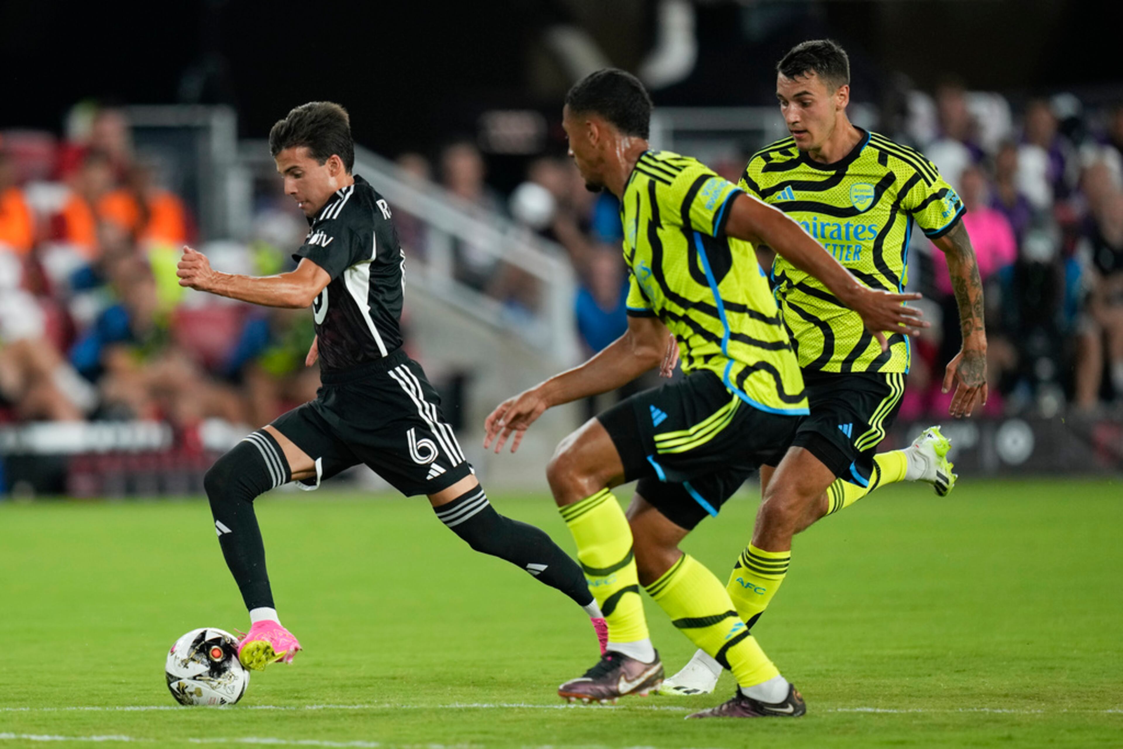 LA Galaxy midfielder Riqui Puig, left, drives the ball past Arsenal defenders William Saliba and Jakub Kiwior in the first half of the MLS All-Star soccer match, Wednesday, July 19, 2023, in Washington. (AP Photo/Alex Brandon)