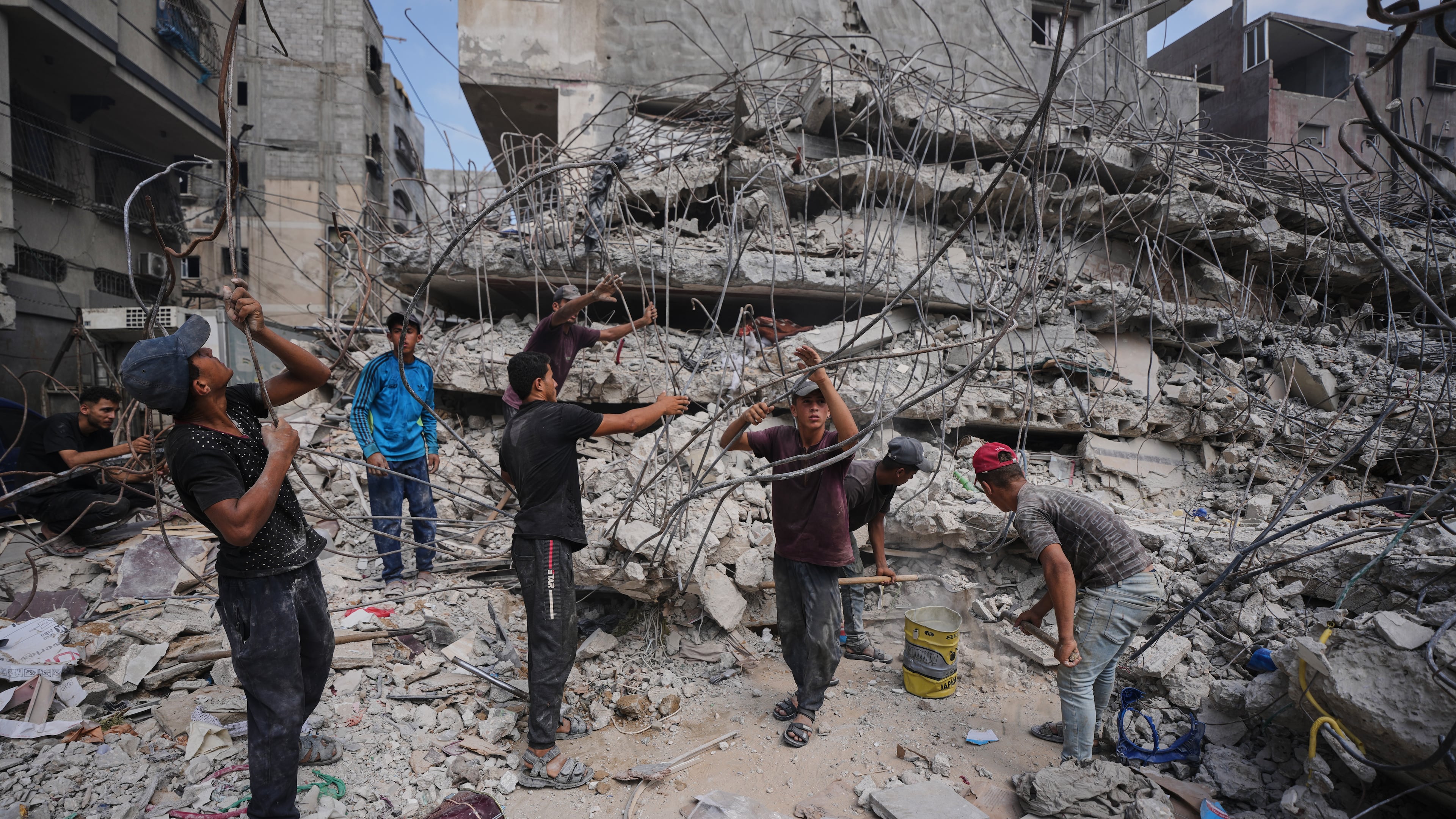 Palestinians remove iron from the rubble of buildings destroyed by Israeli airstrikes during the war with Hamas, repair and recycle it for construction, building tents or selling it, in Gaza City, Sunday, Aug. 16, 2026. (AP Photo/Jehad Alshrafi)
