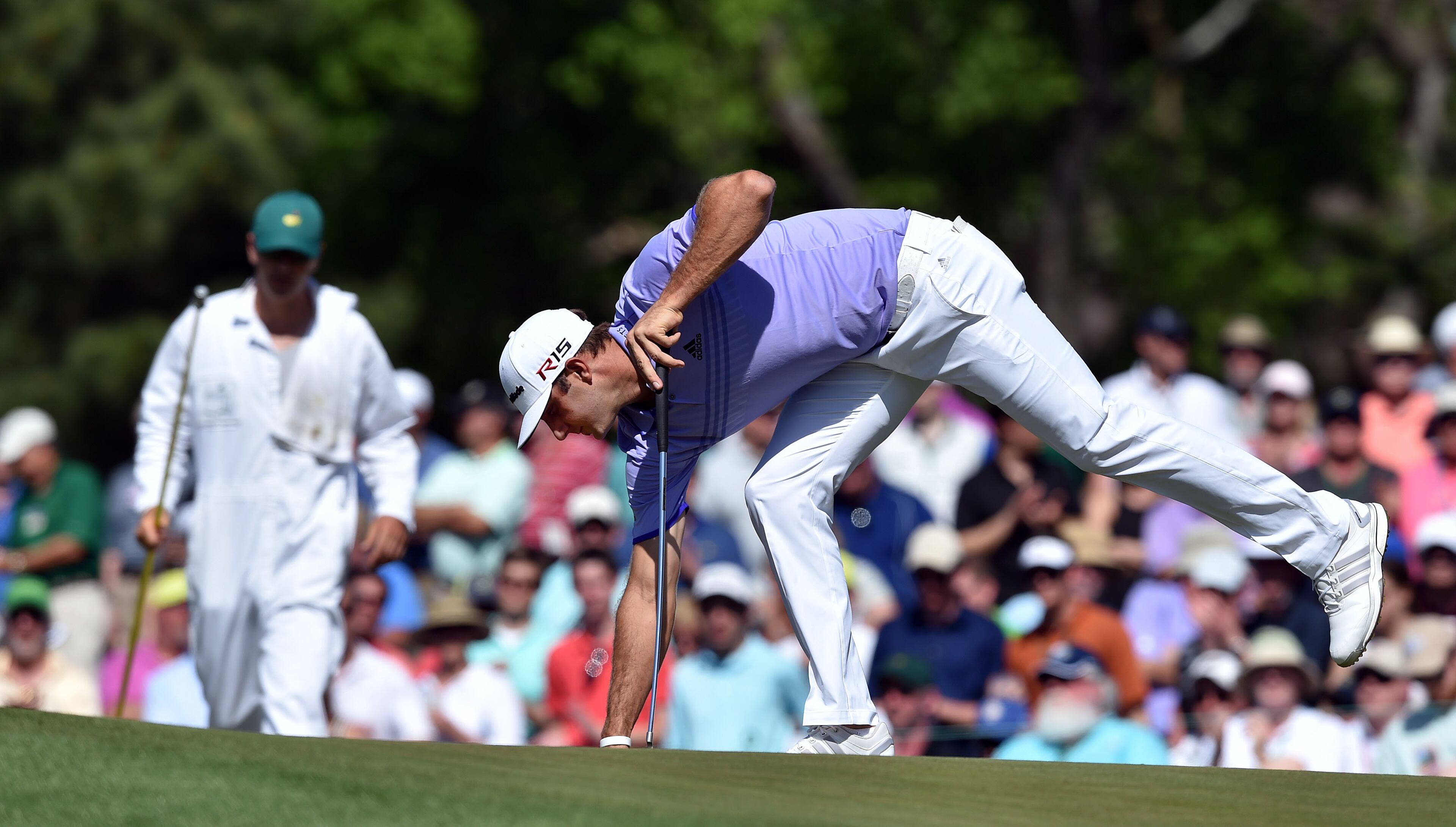 Dustin Johnson gets his ball after a par putt. Photos from the third round at the Masters Golf Tournament, Saturday, April 11, 2015. BRANT SANDERLIN/BSANDERLIN@AJC.COM