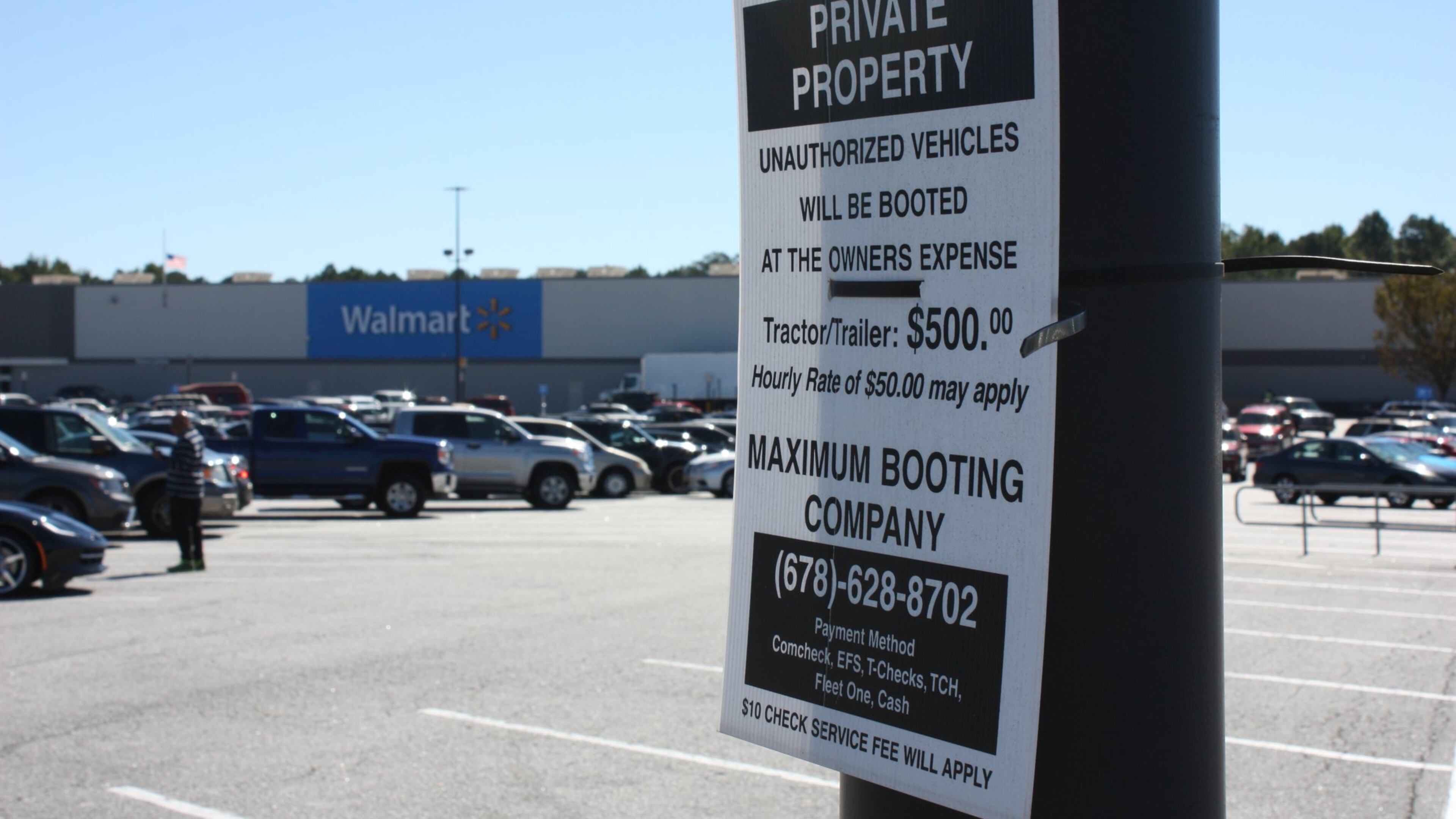 Signs in the Newnan Crossing shopping center in Newnan, Ga., warn owners of “unauthorized vehicles” they are subject to booting. CHRIS JOYNER / CJOYNER@AJC.COM