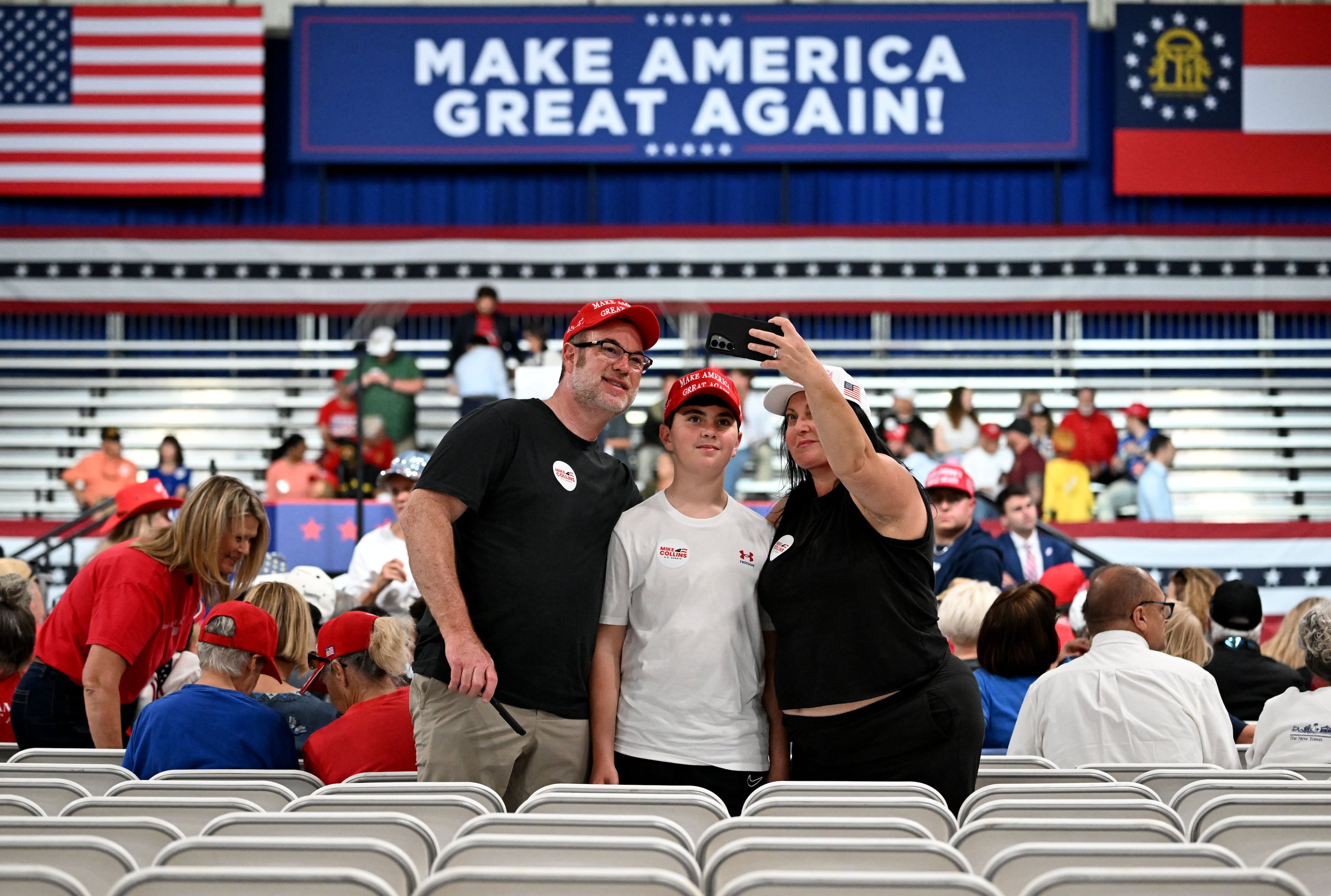 Attendees take a selfie as they arrive for a President Donald Trump rally at Guardian Centers in Perry on Saturday, Oct. 24, 2026. (Hyosub Shin/AJC)