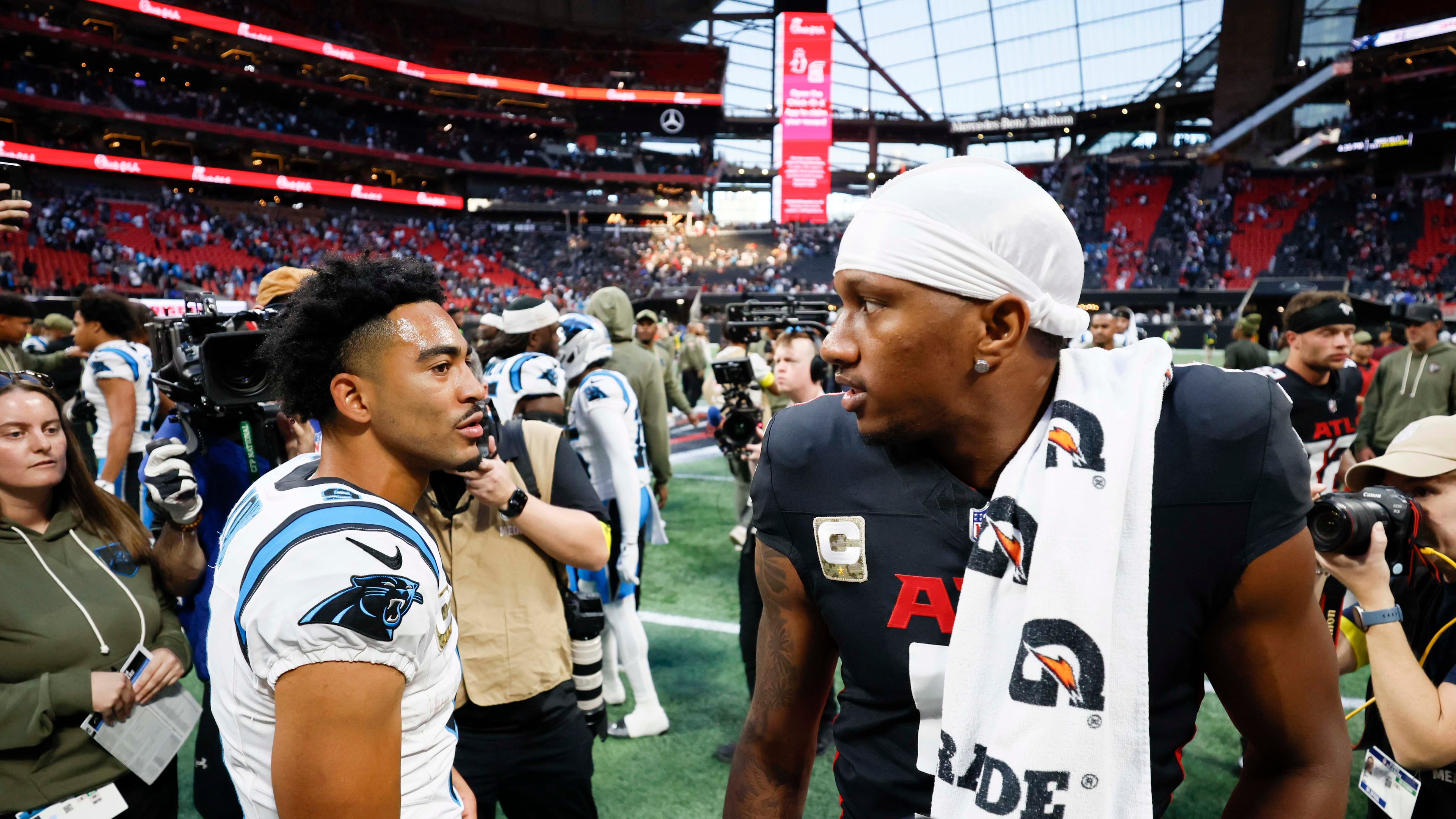 Atlanta Falcons quarterback Michael Penix Jr. (right) interacts with Carolina Panthers quarterback Bryce Young (left) at the end of the game. The Carolina Panthers defeated the Atlanta Falcons in overtime, 30-27, at Mercedes-Benz Stadium in Atlanta on Sunday, Nov. 16, 2025. (Miguel Martinez/AJC)