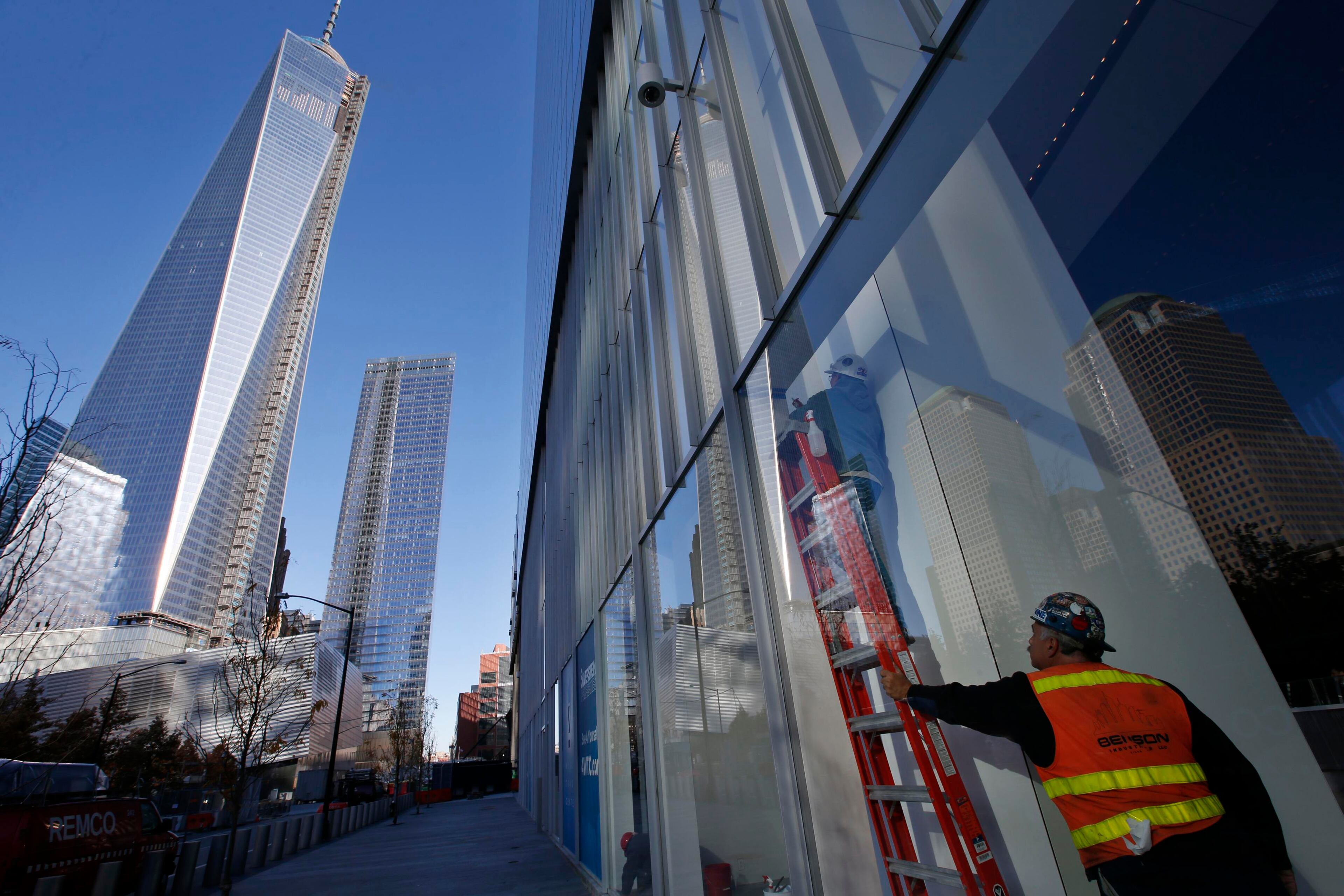 Workers put finishing touches on a window in the lobby of the soon to be opened 4 World Trade Center tower in New York, November 8, 2013. 4 World Trade center sits at the south east corner of the World Trade Center site and will be the second tower to open on the site since the 2001 attacks on the World Trade Center. REUTERS/Mike Segar (UNITED STATES - Tags: BUSINESS CITYSCAPE)