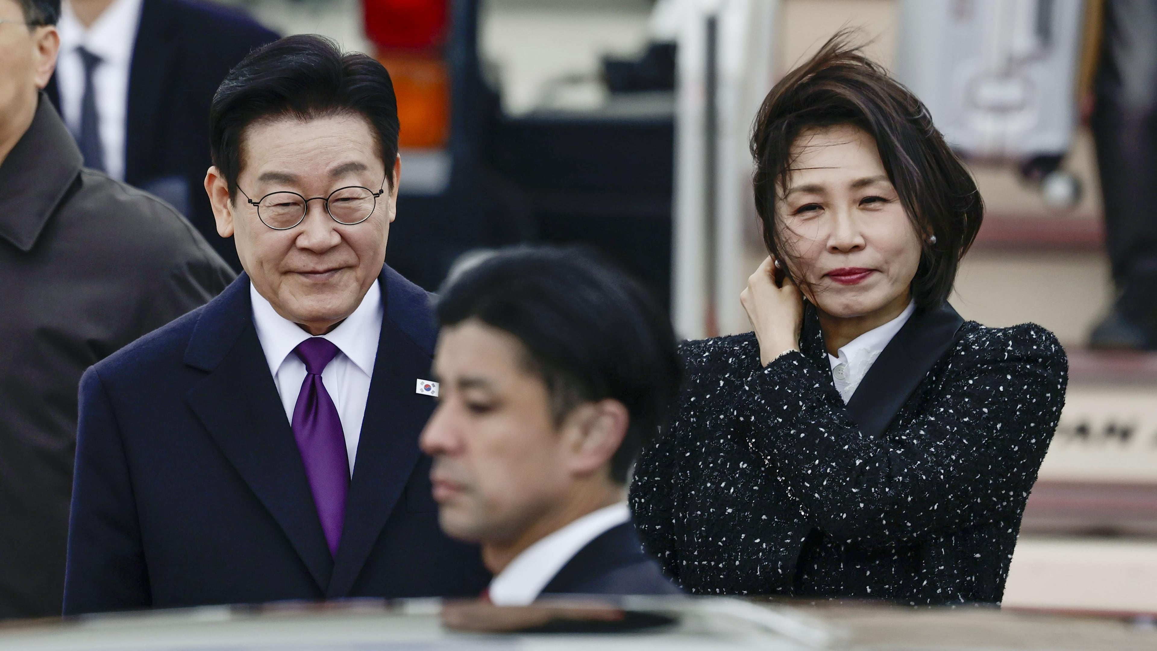 South Korean President Lee Jae Myung, left, and his wife Kim Hea Kyung, right, arrive at Kansai International Airport in Izumisano city, Osaka, western Japan, Tuesday, Jan. 13, 2026. (Kyodo News via AP)