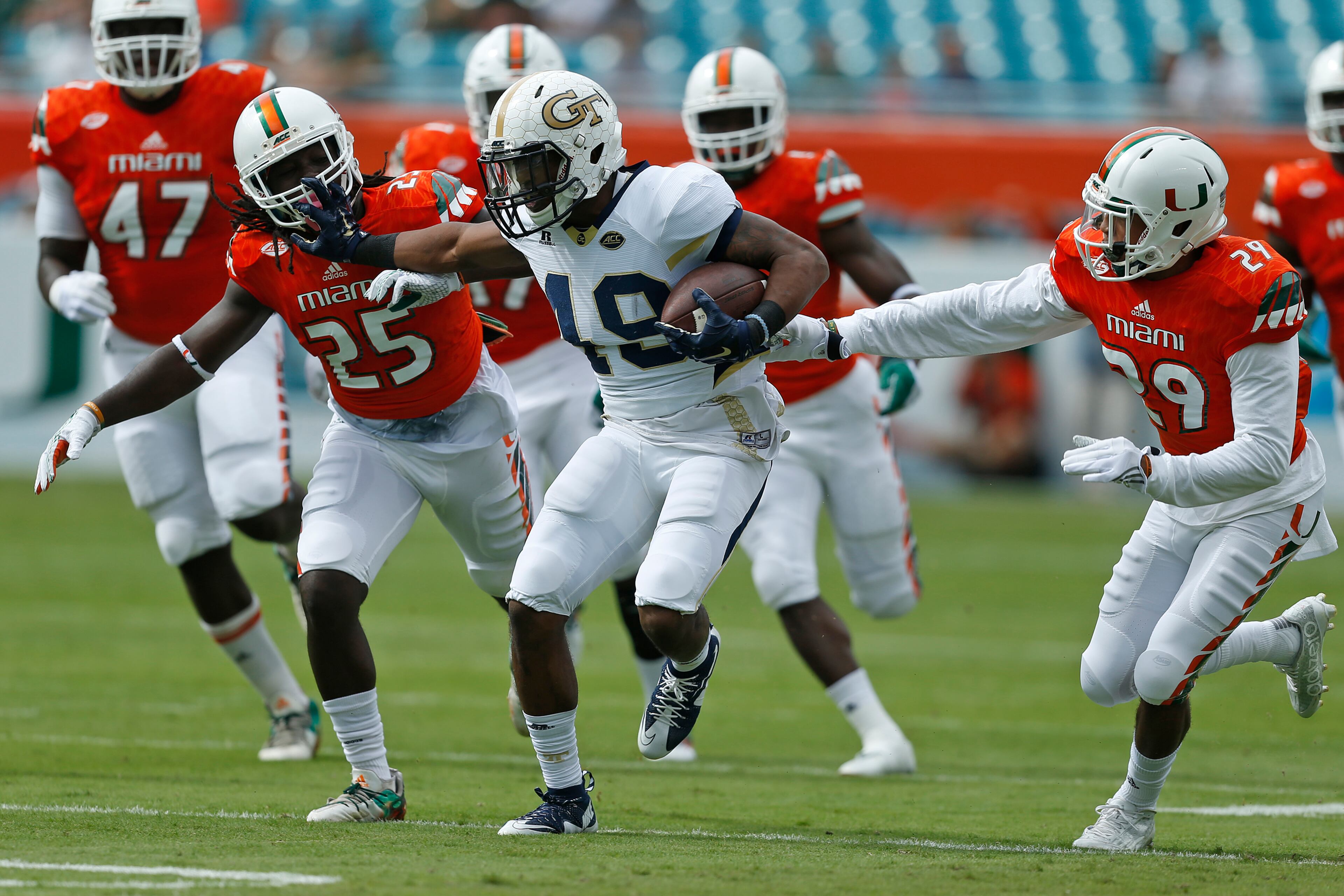 MIAMI GARDENS, FL - NOVEMBER 21: Clinton Lynch #49 of the Georgia Tech Yellow Jackets runs with the ball between Corn Elder #29 and Dallas Crawford #25 of the Miami Hurricanes on November 21, 2015 at Sun Life Stadium in Miami Gardens, Florida.(Photo by Joel Auerbach/Getty Images)