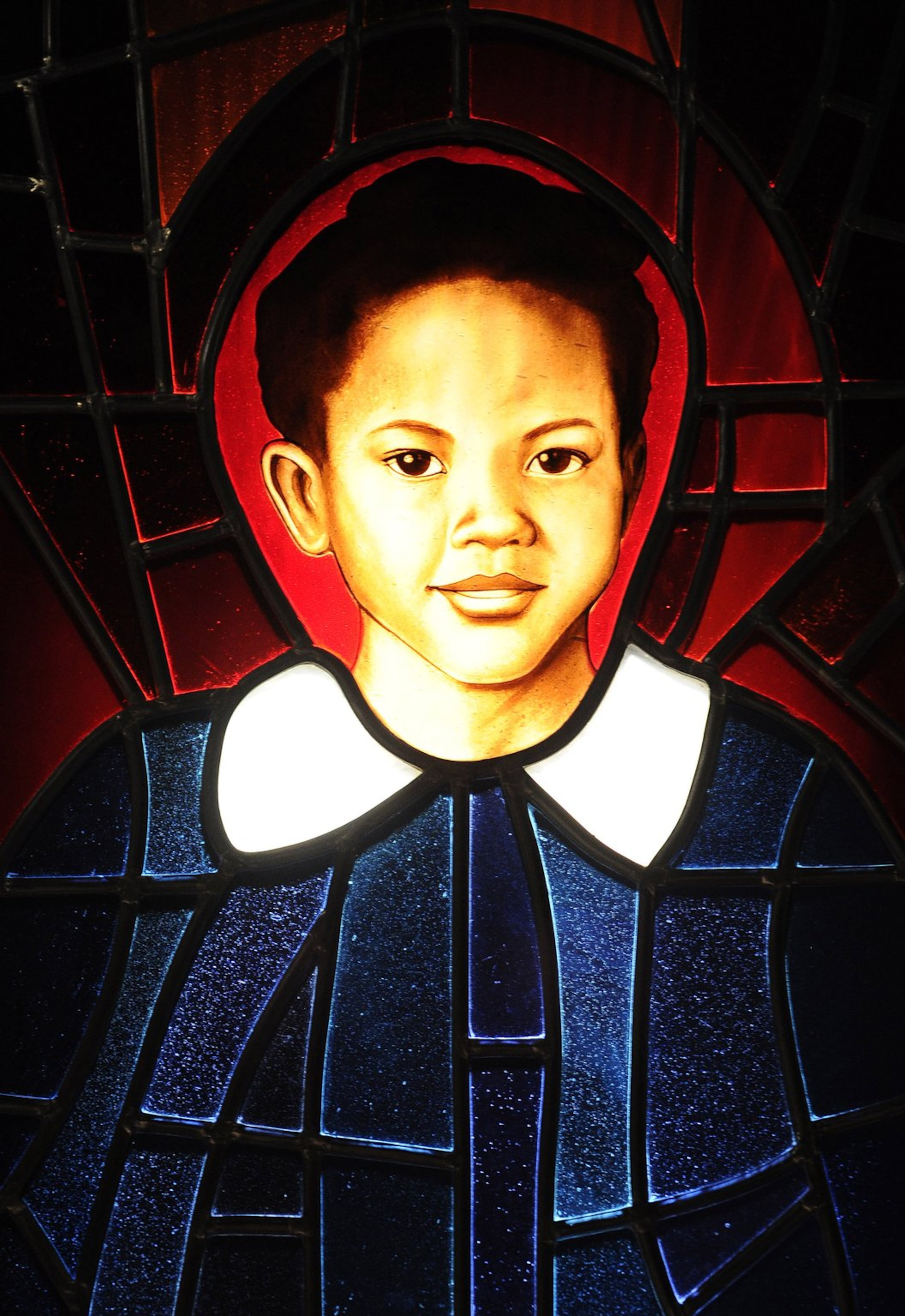 A stained-glass portrait of Addie Mae Collins, one of the four young girls killed in the Birmingham church bombing of 1963, hangs at the National Center for Civil and Human Rights in Atlanta.. David Tulis / AJC Special