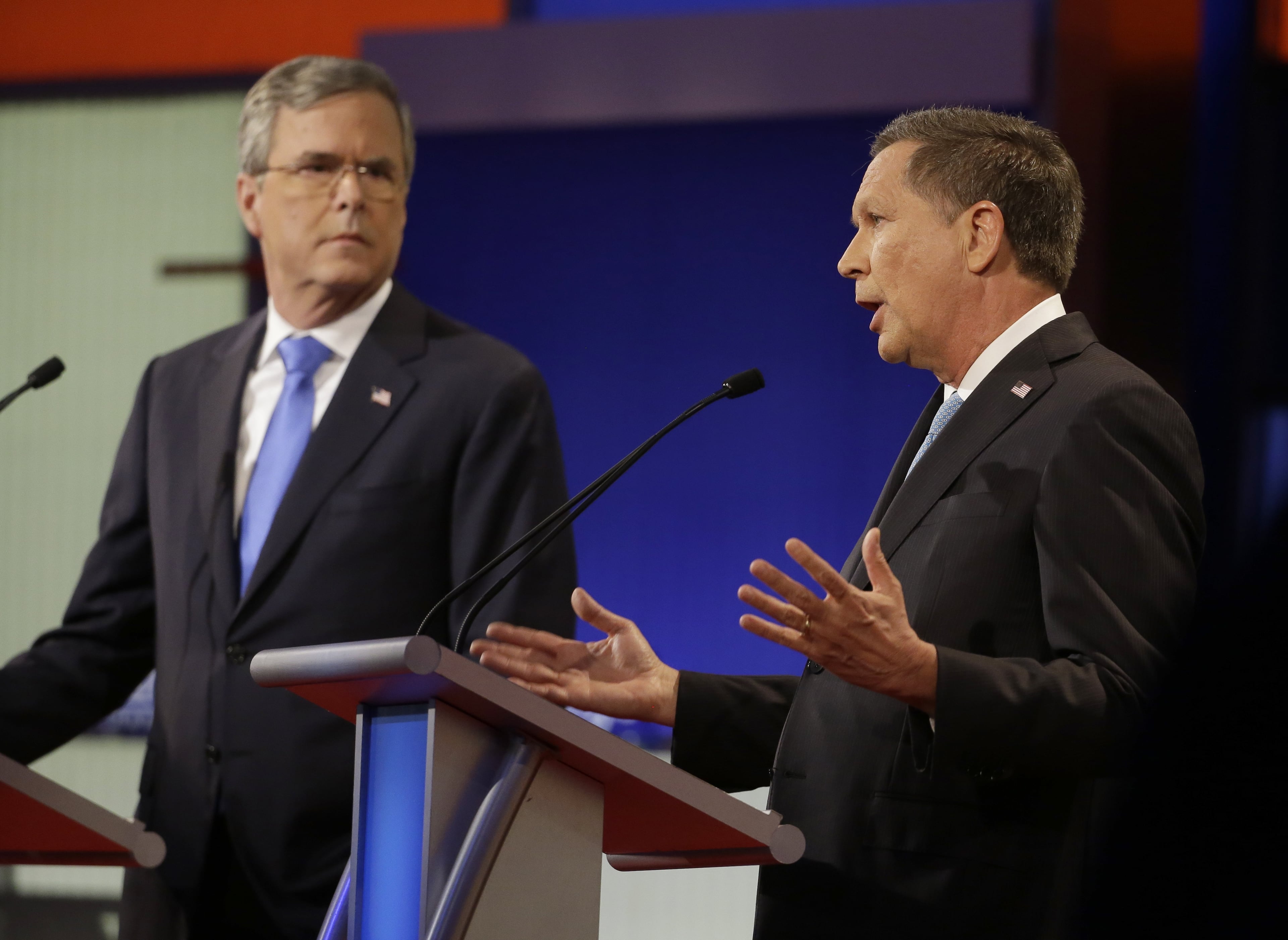 John Kasich, right, speaks as Jeb Bush listens during a Republican presidential primary debate, Thursday, Jan. 28, 2016, in Des Moines, Iowa. (AP Photo/Chris Carlson)