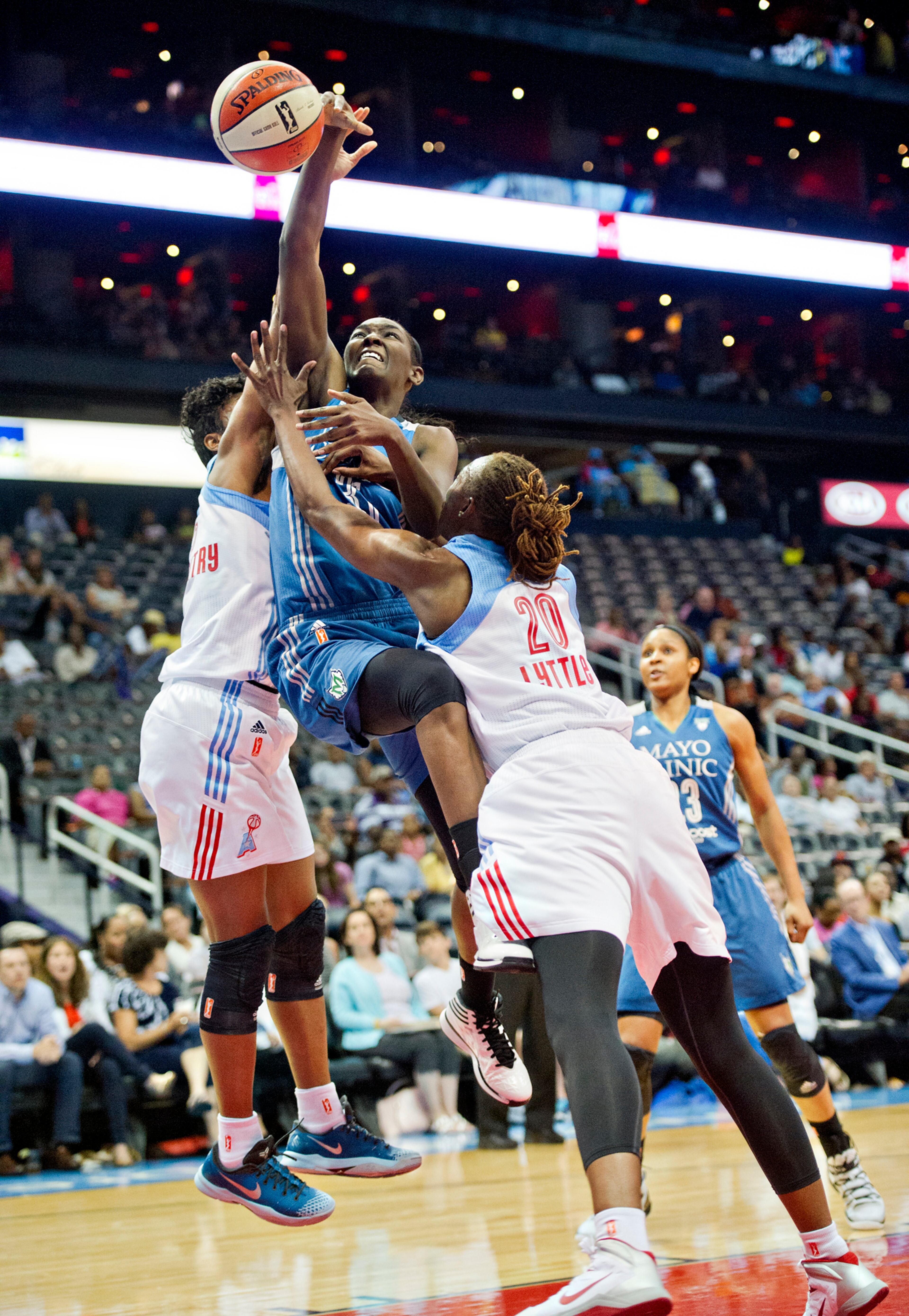 Minnesota's Asia Taylor (center) tries to get the ball past Atlanta's Sancho Lyttle (20) and Angel McCoughtry (left) during their game at Philips Arena in Atlanta on Friday, June 13, 2014.