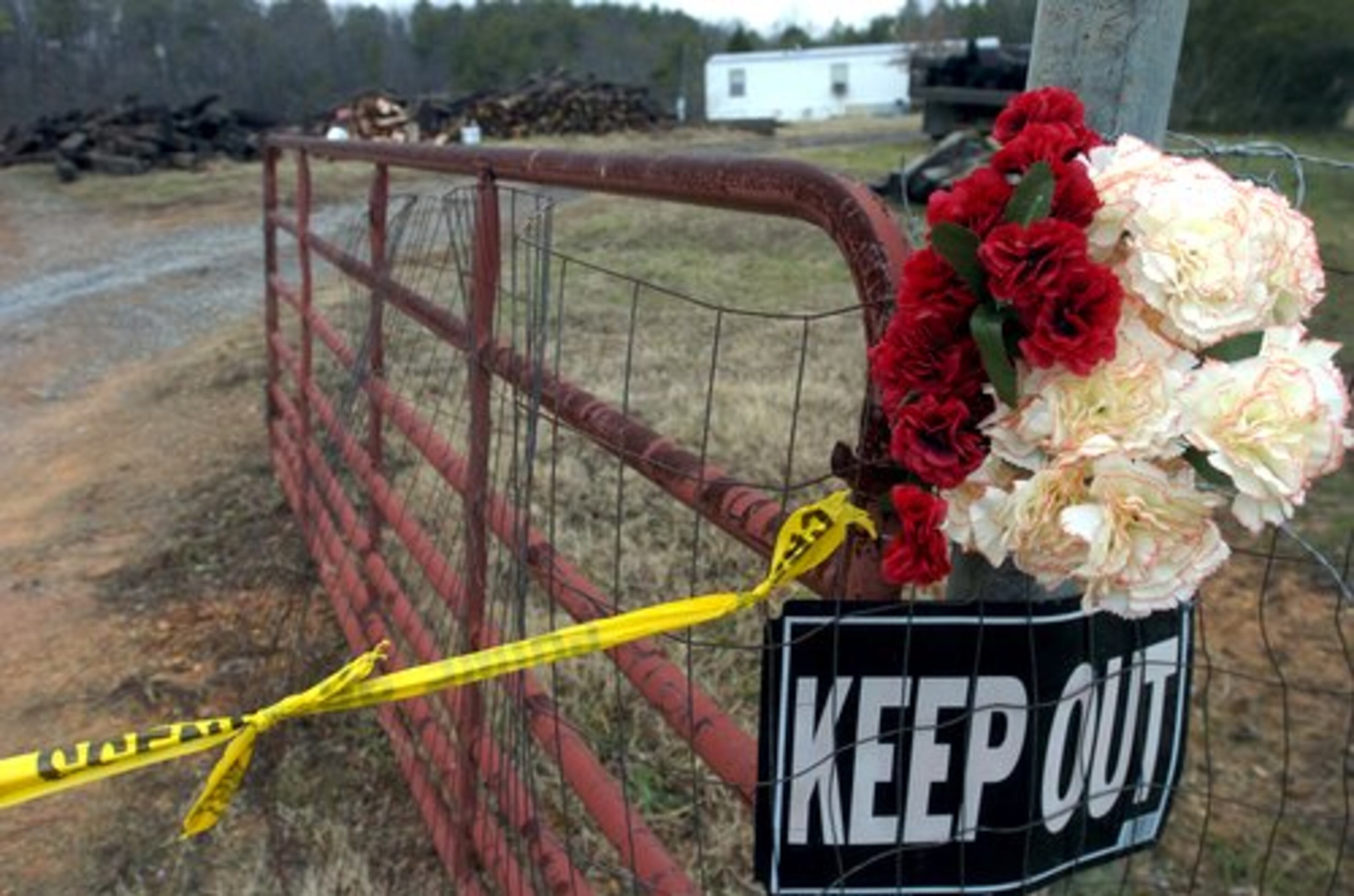 January 2004: Crime scene tape and memorial flowers mark the property in Ranger where four people were killed.
