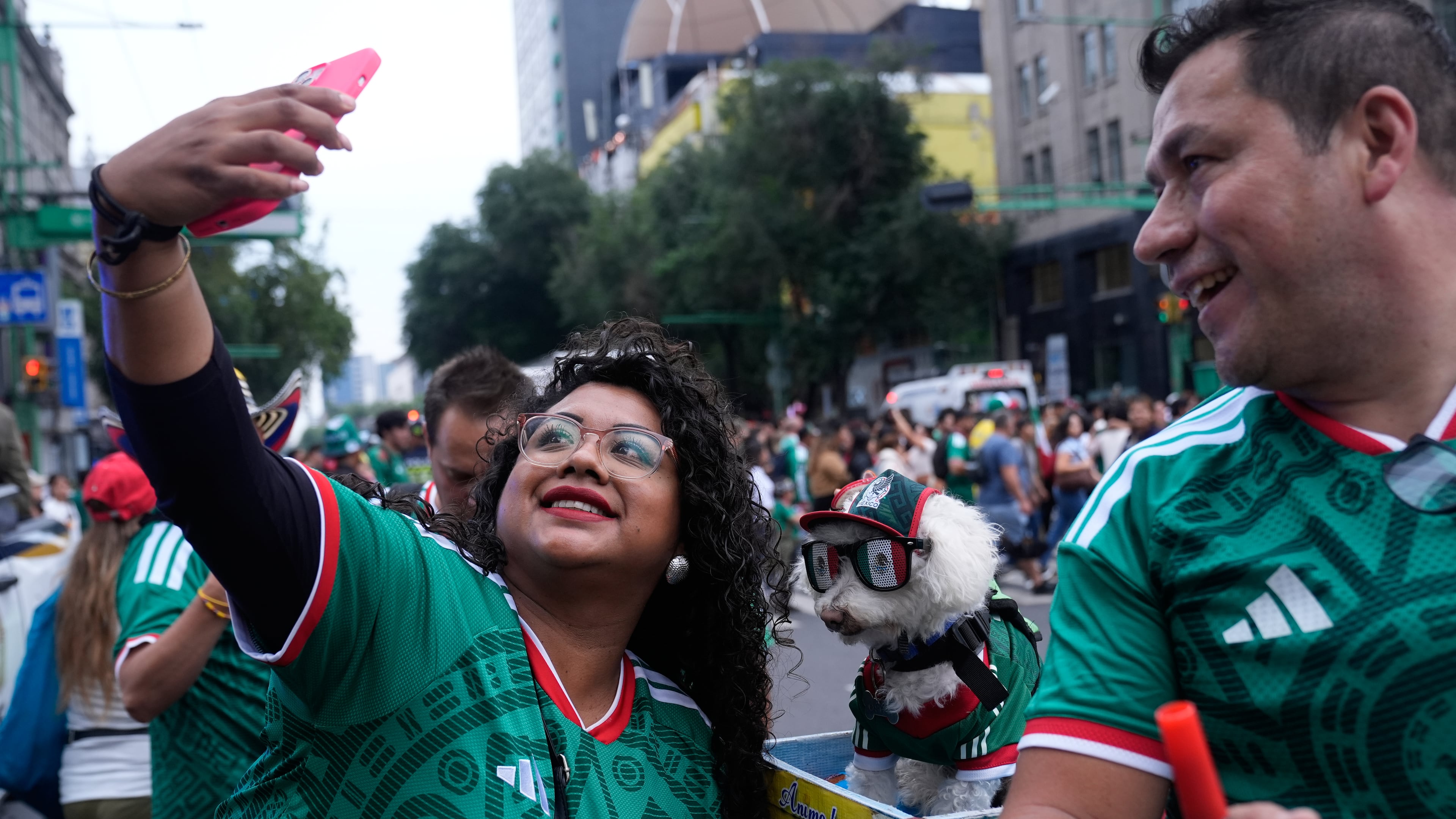 A fan, left, takes a photo with a dog named Osito, wearing a Mexico national soccer team jersey, next to Jorge Rangel before the World Cup Group A soccer match against South Korea in Mexico City, Thursday, June 18, 2026. (AP Photo/Marco Ugarte)